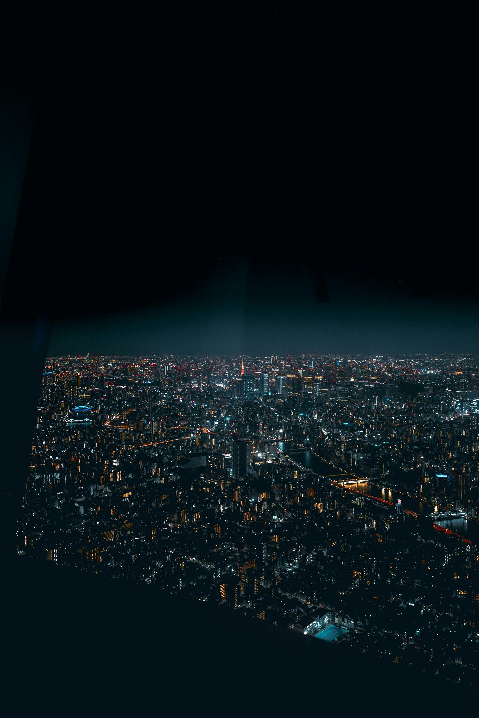 Luftaufnahme einer Stadt bei Nacht mit leuchtenden Wolkenkratzern