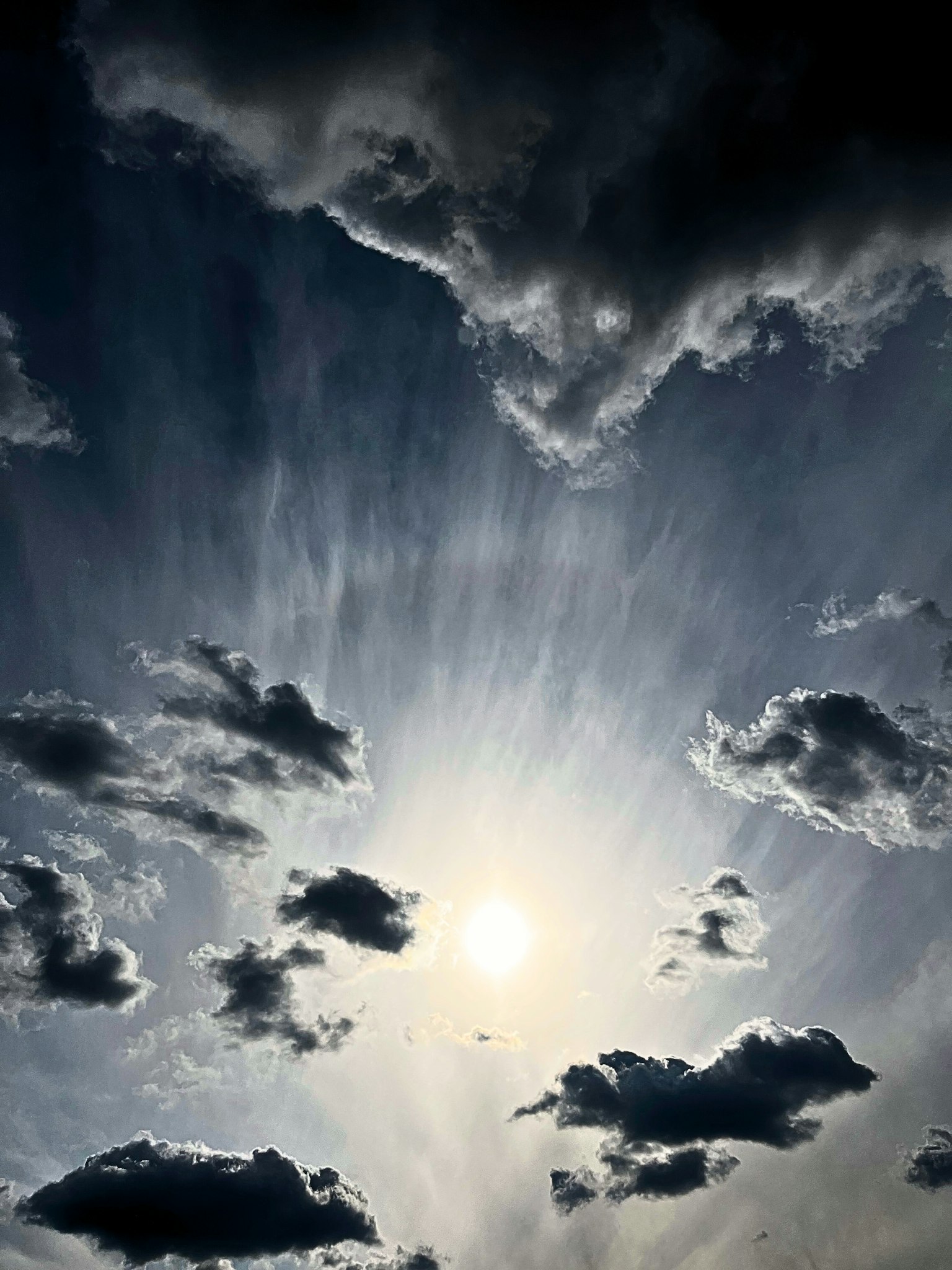 Beautiful view of clouds and sunlight radiating in a blue sky