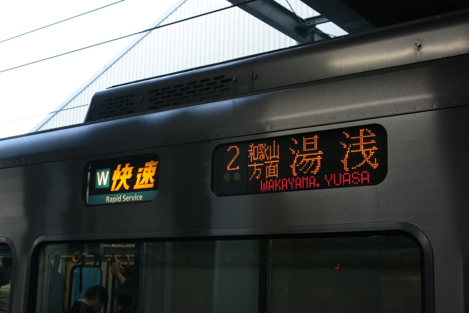 Pantalla del tren mostrando '2 Yuasawa' con un letrero de servicio rápido