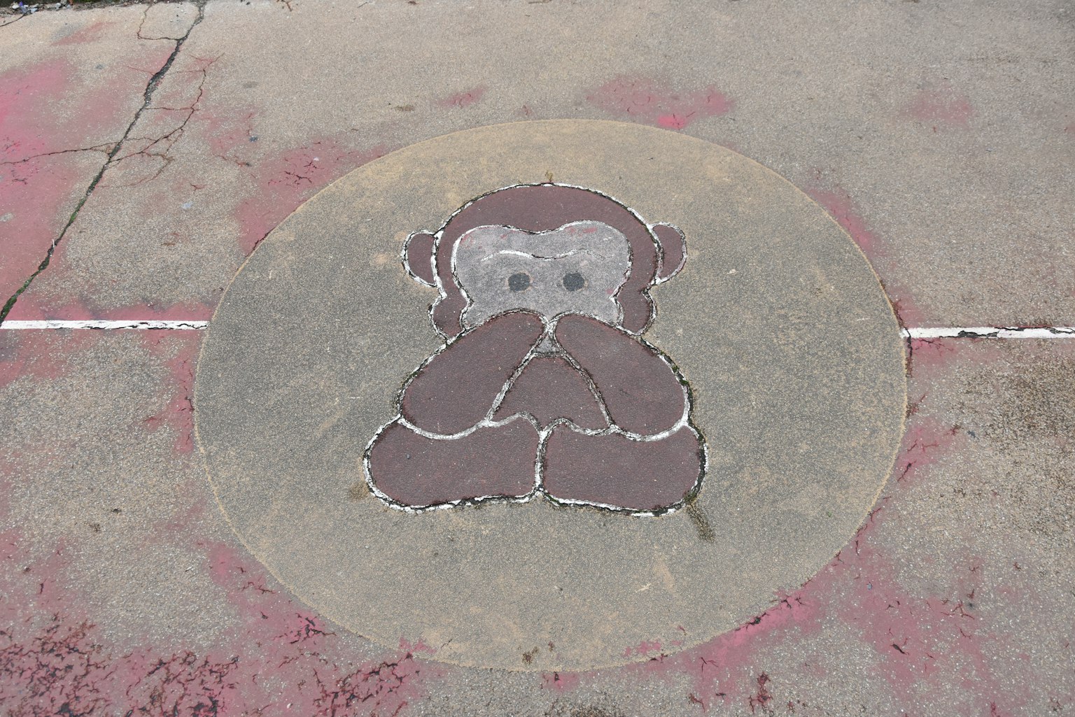 Une illustration de singe mignonne peinte au sol à l'intérieur d'un cercle