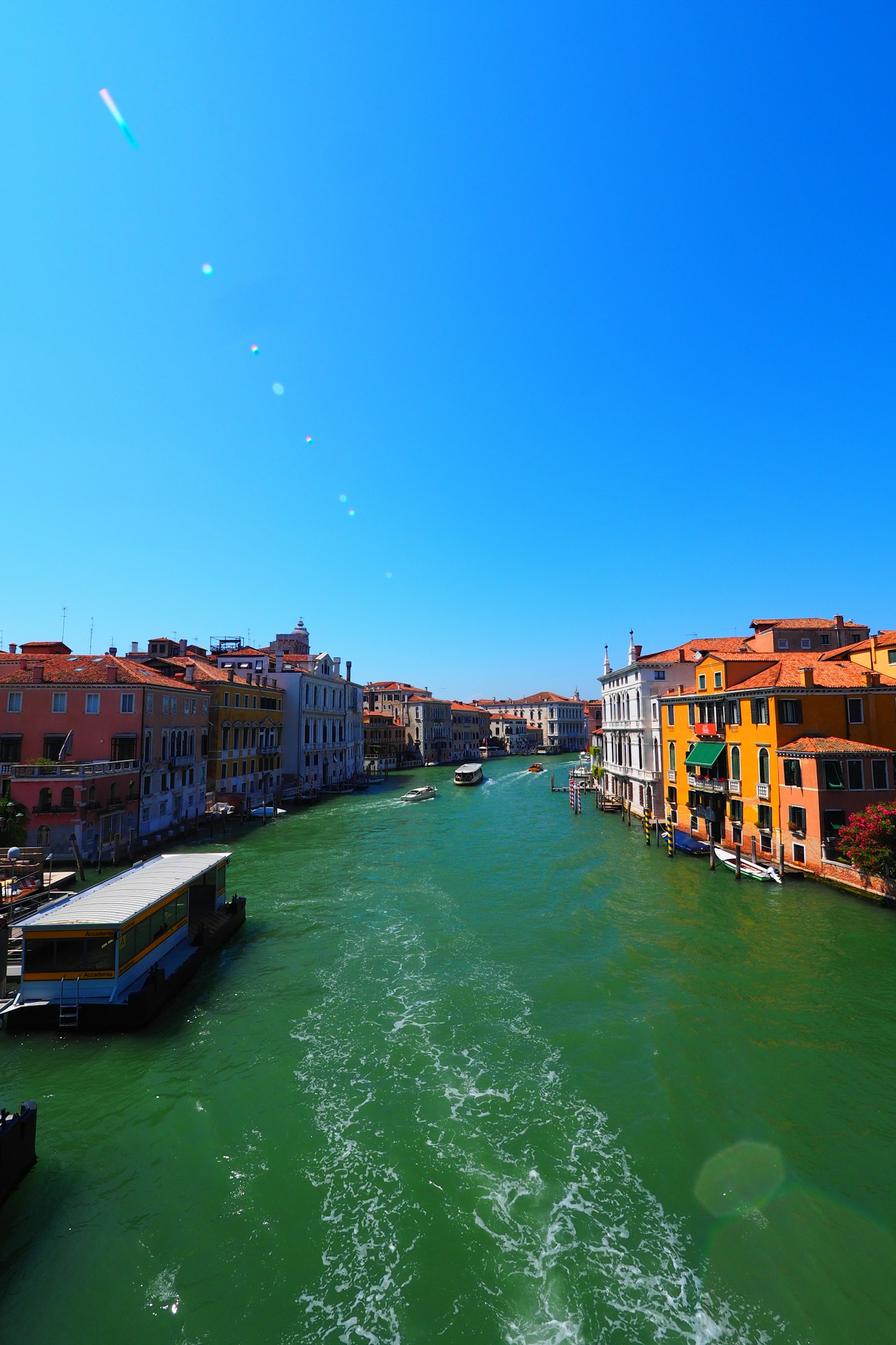 Paisaje veneciano con un canal verde bajo un cielo azul