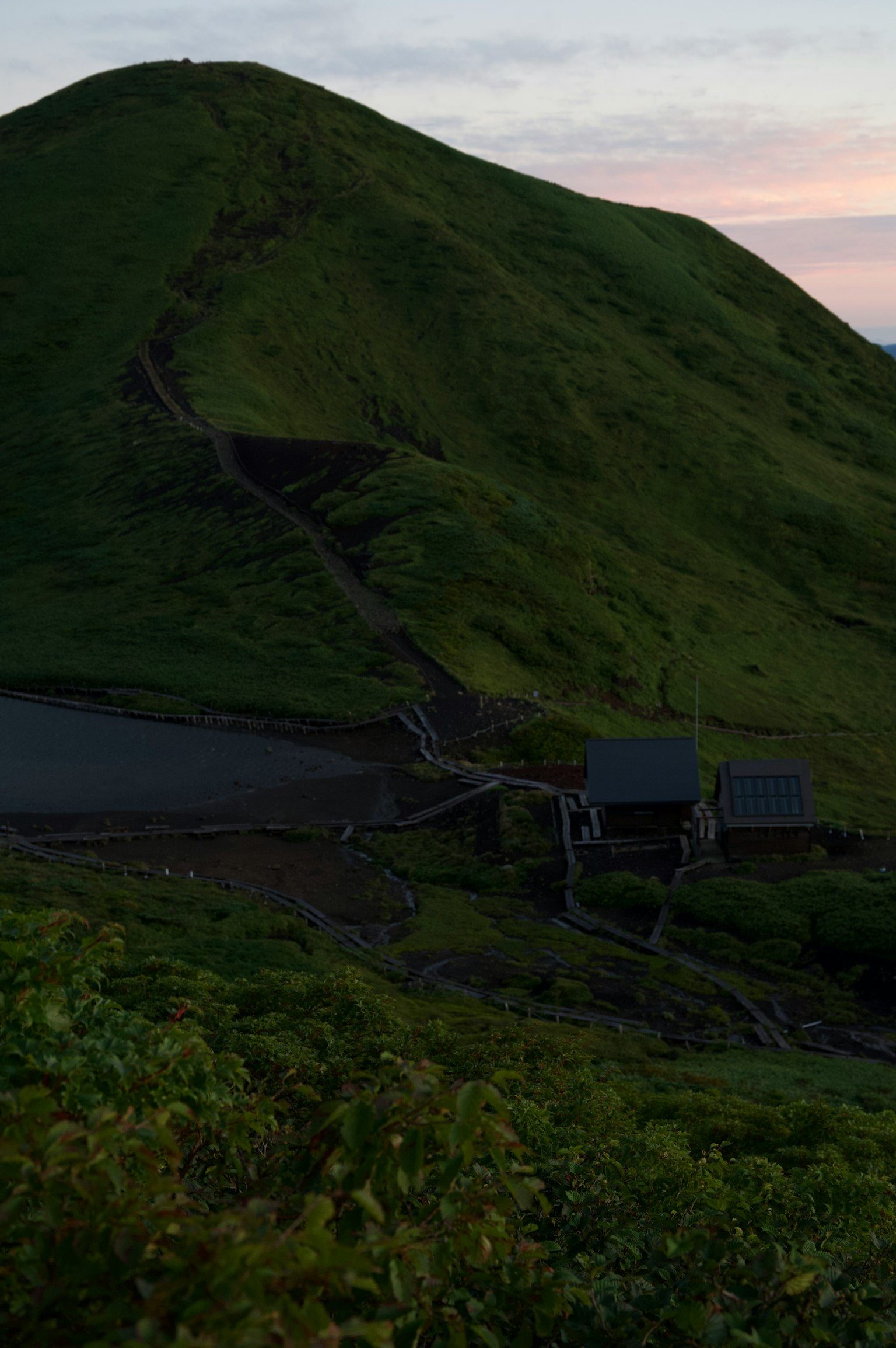 綠色山丘的風景，有一條小路和小建築
