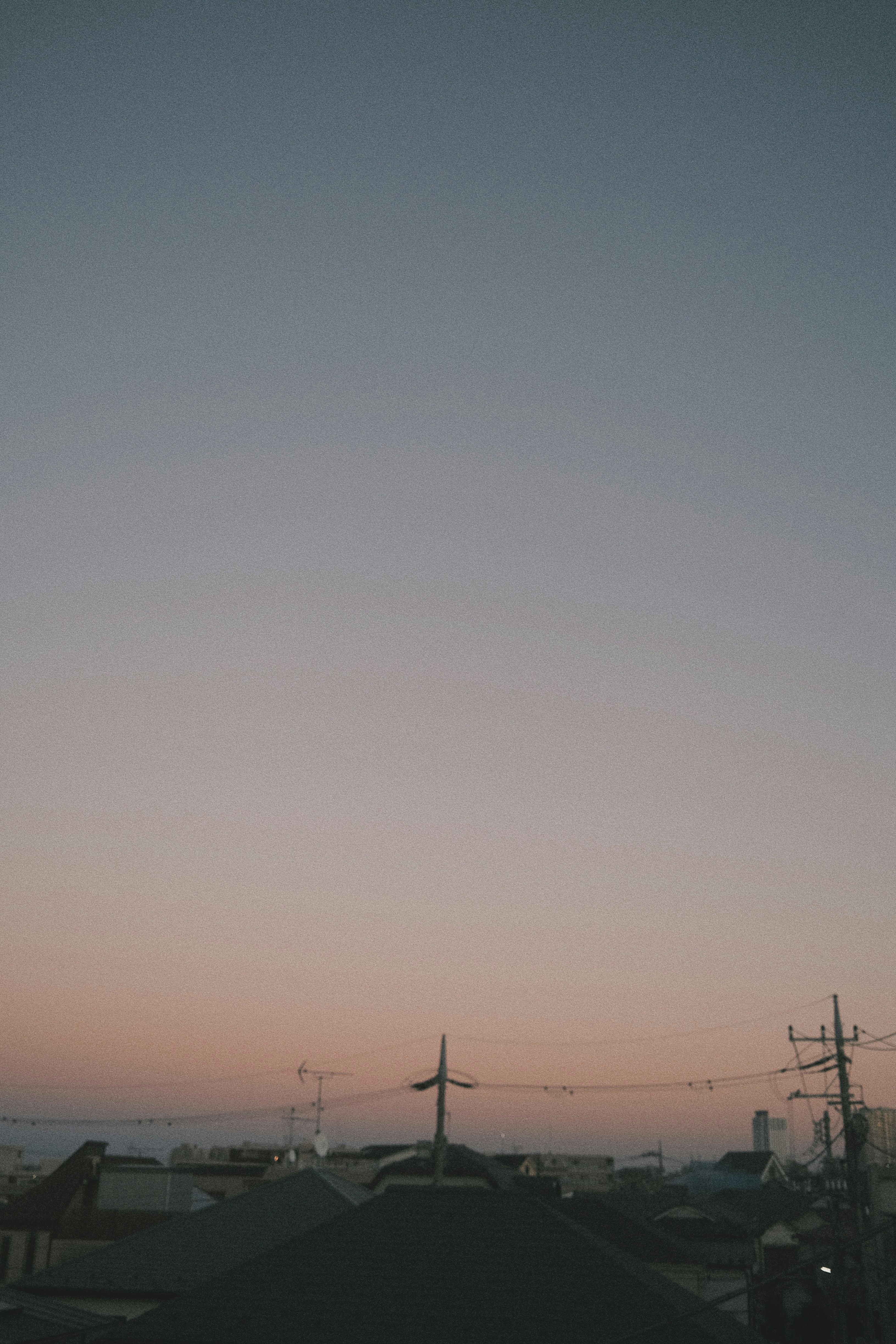 夕焼けの空と電線のある郊外の道