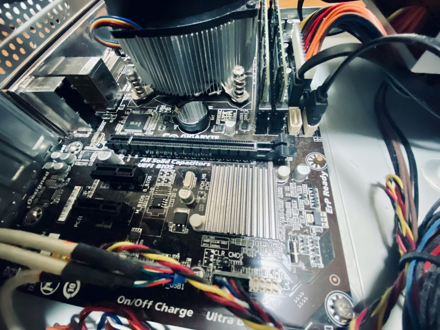Vista ravvicinata di una scheda madre di computer con dissipatore di calore e cablaggio visibili