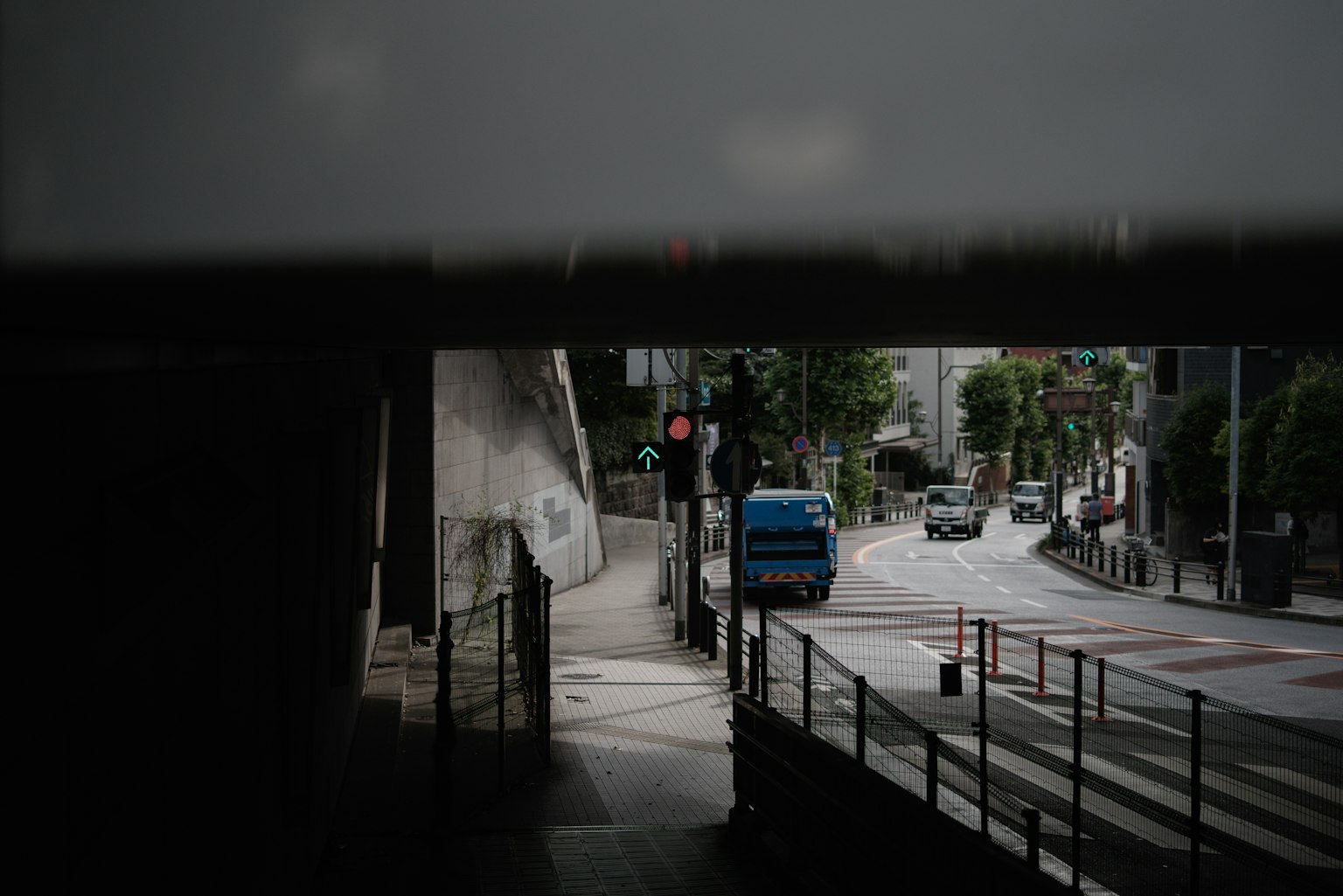 从隧道出口看到的城市景观，有车辆和交通信号