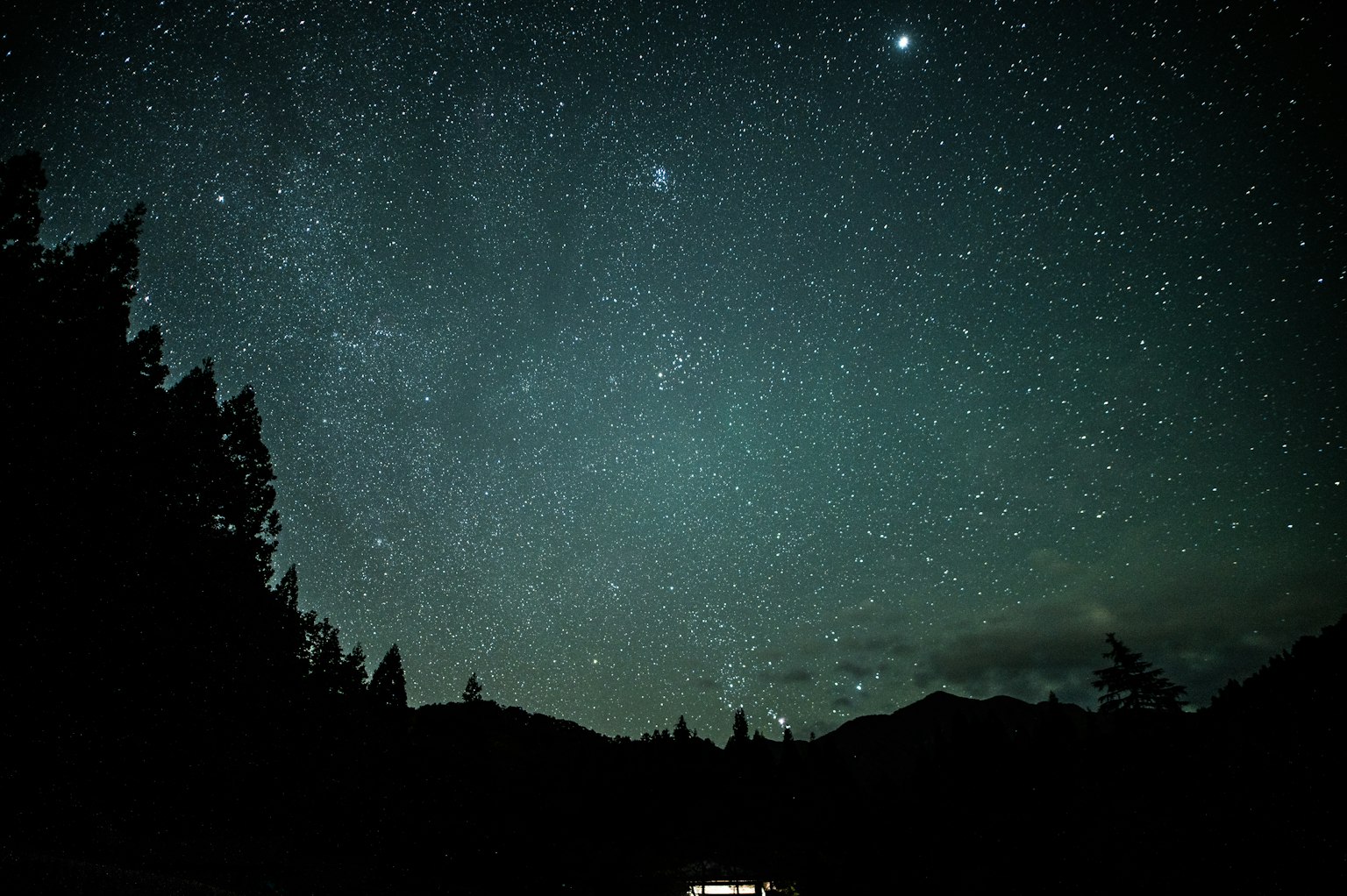 Cielo stellato con silhouette di montagne