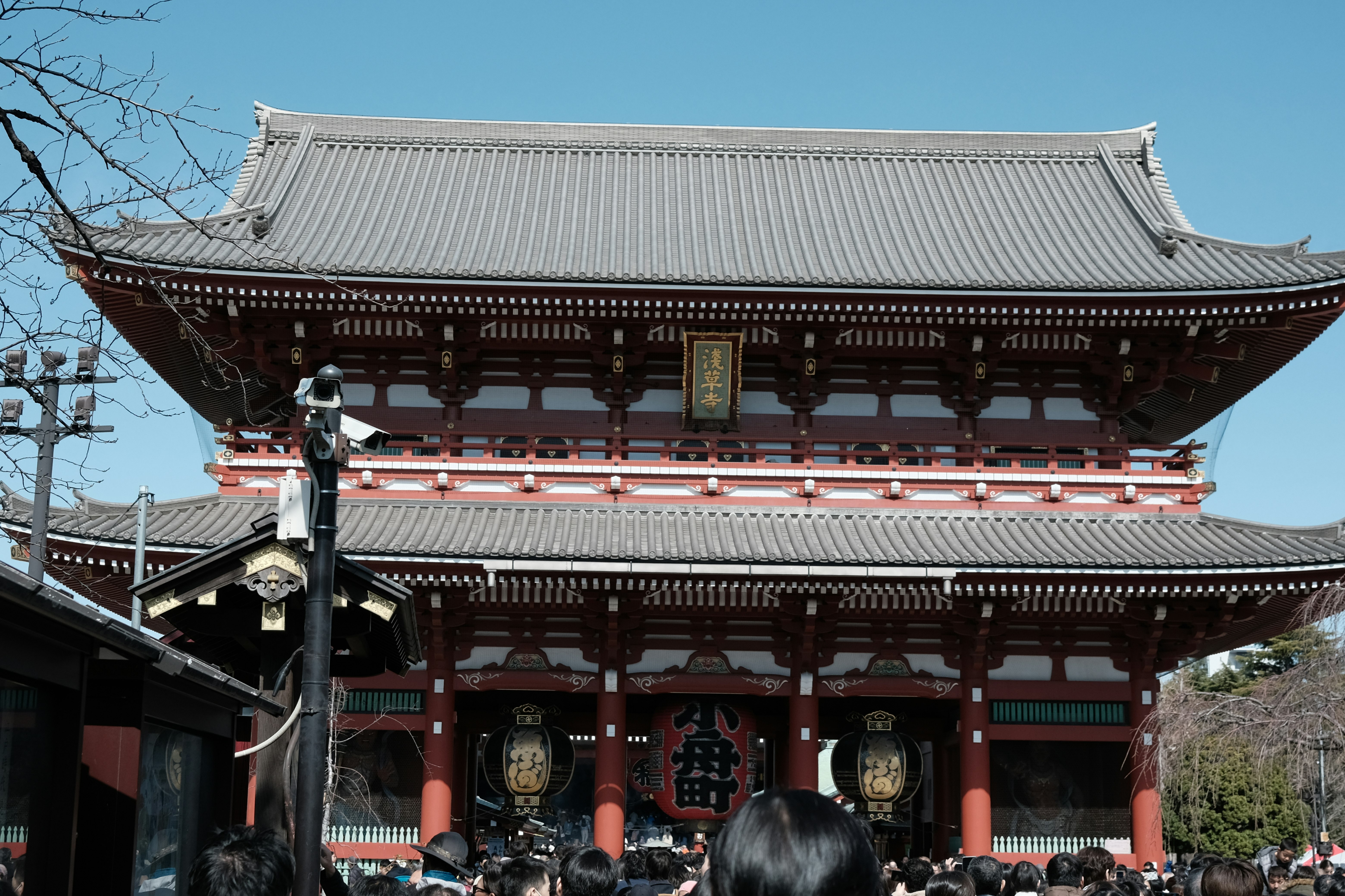 青空の下にそびえる寺院の大きな門と提灯