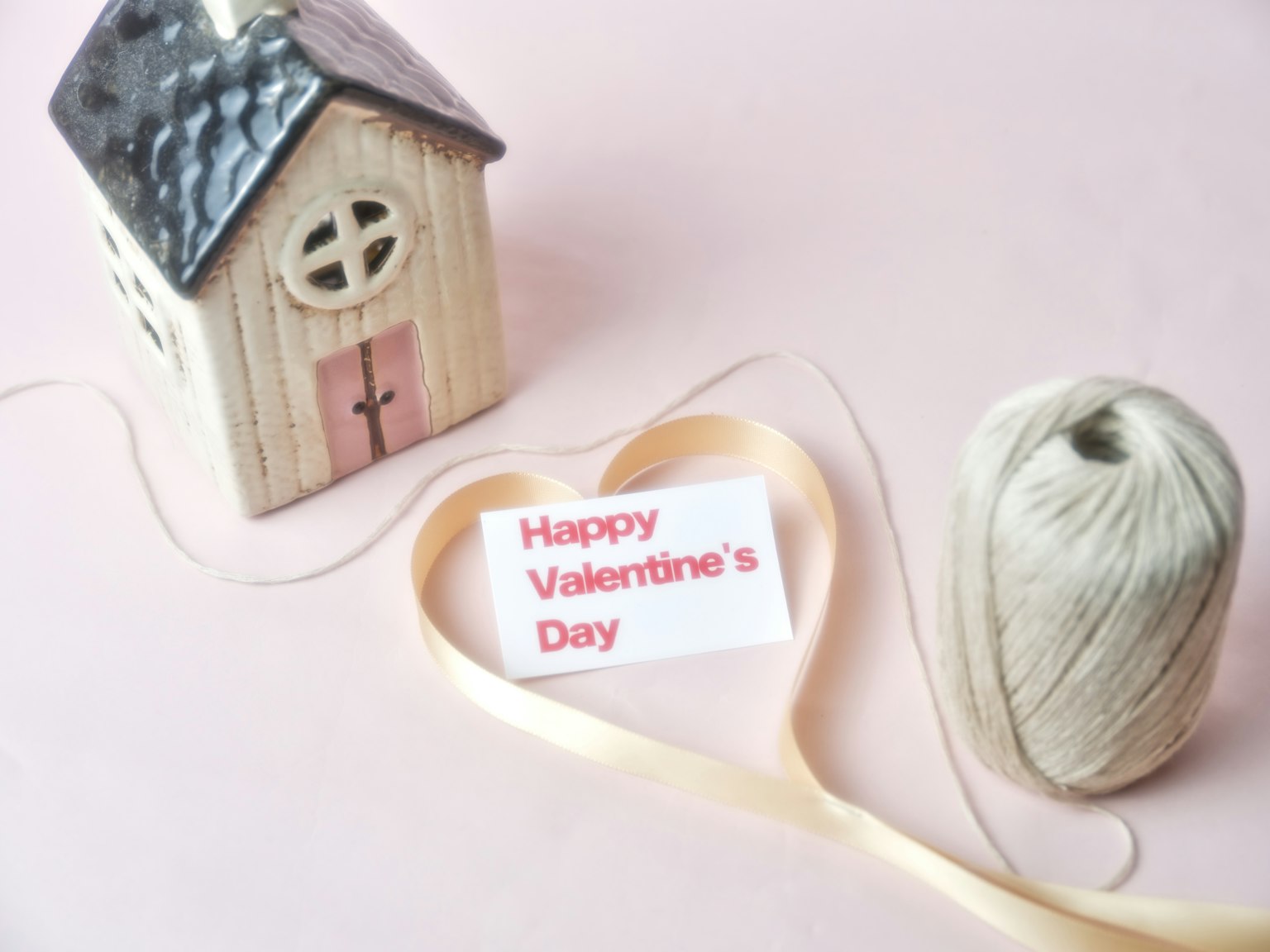 A small wooden house and a ribbon with a Valentine's Day message