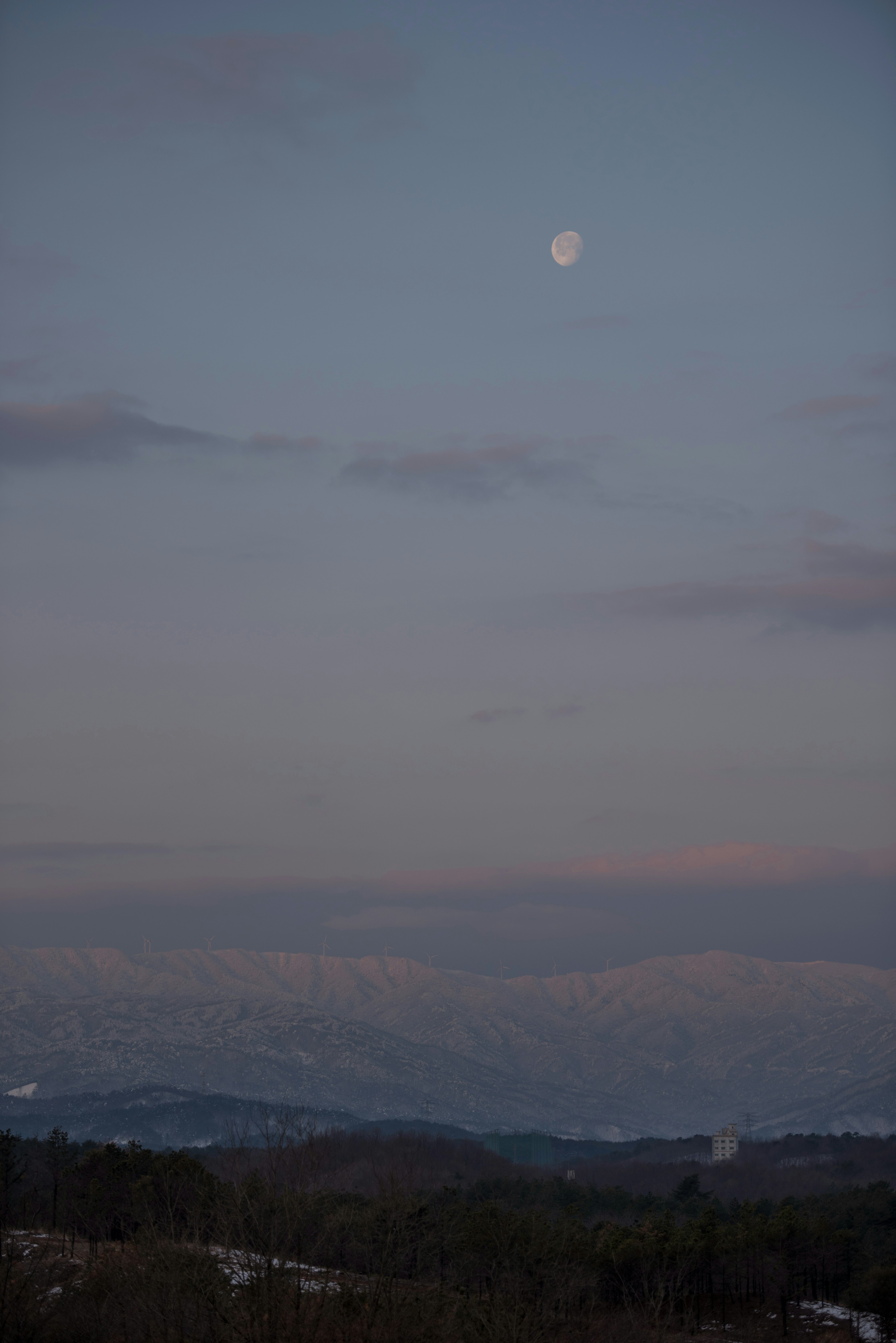 冷たい山並みと薄い空の夕暮れの風景
