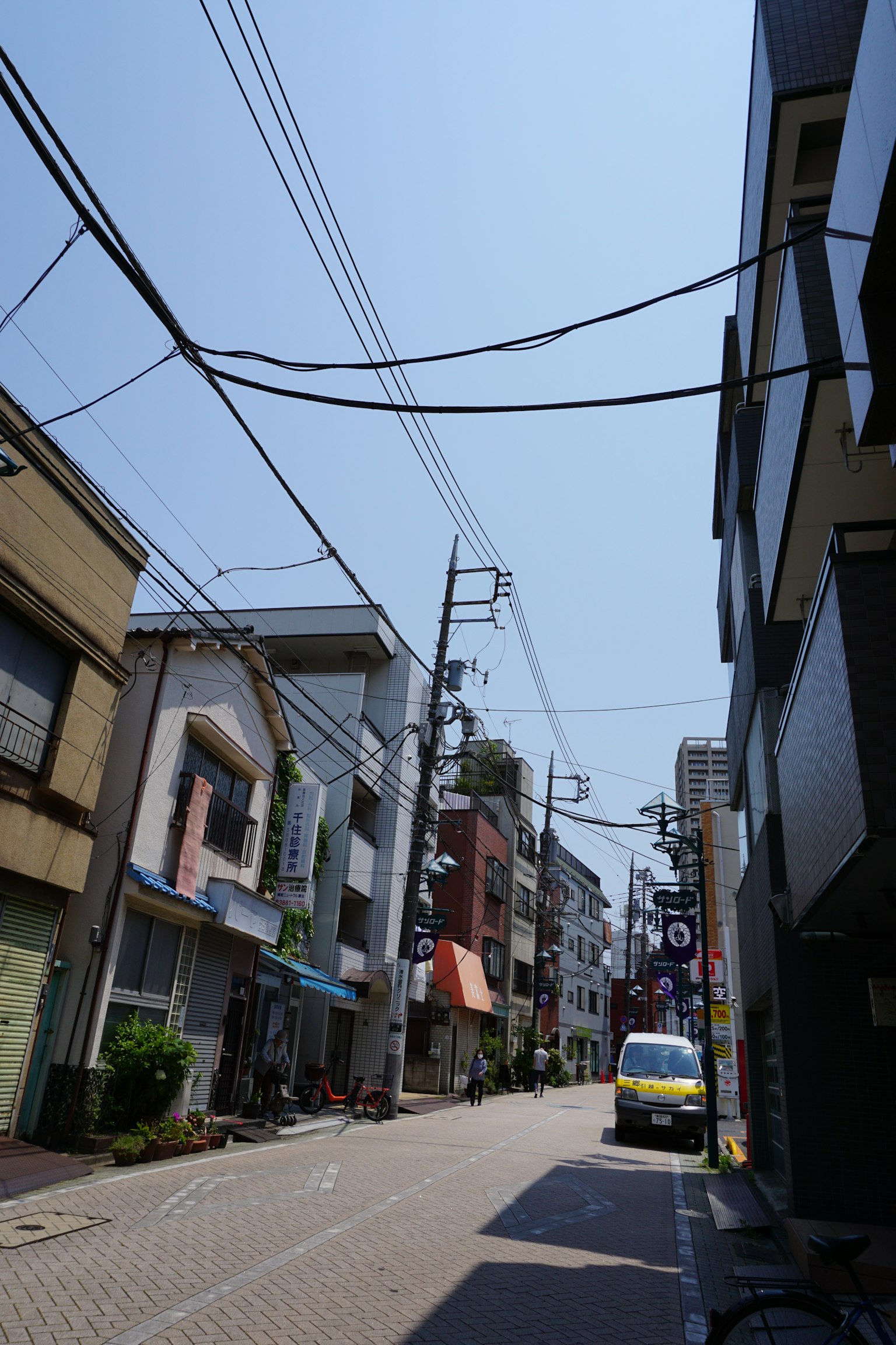 Jalan sempit dengan bangunan rendah di bawah langit biru yang jelas
