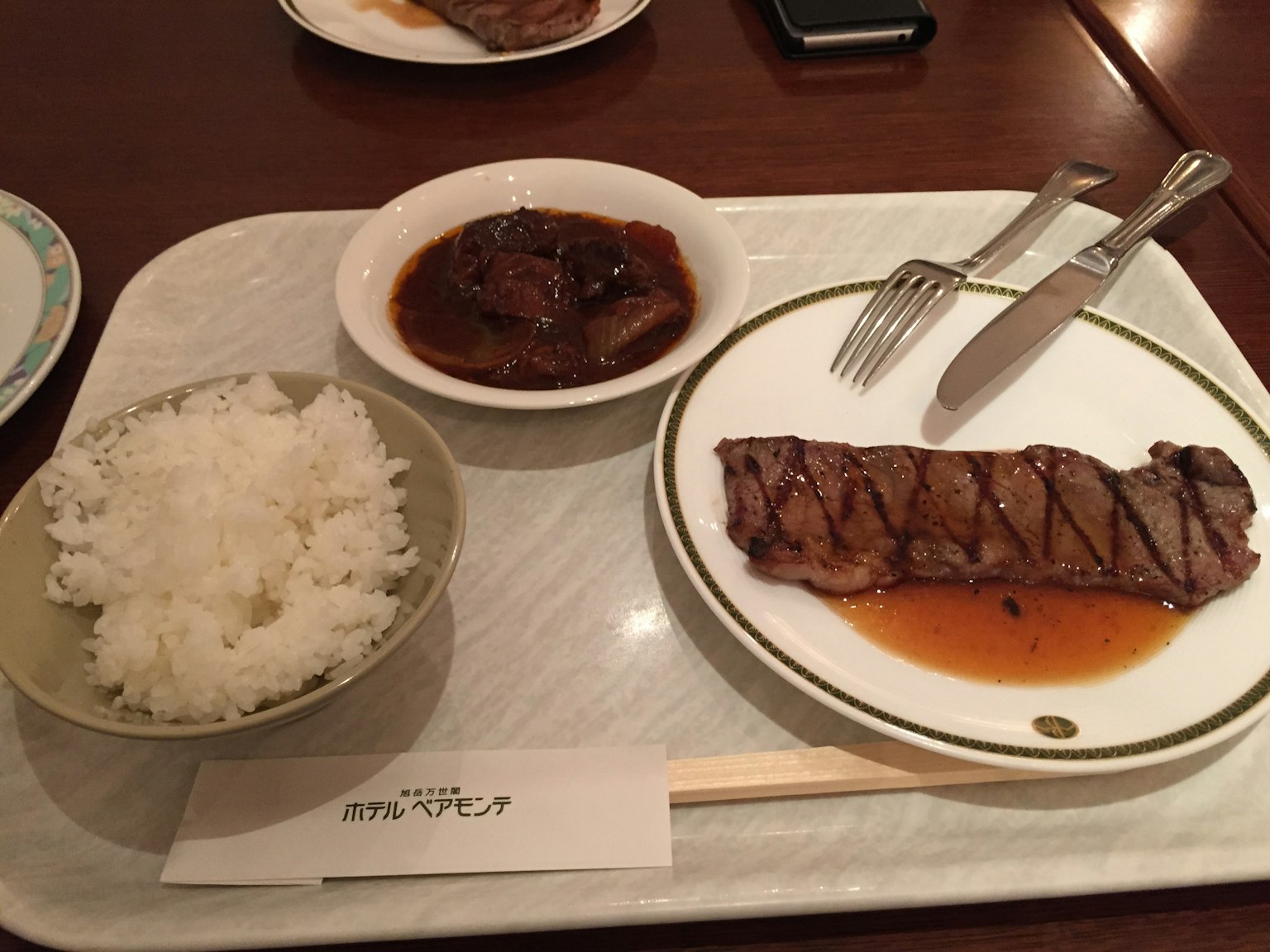Leckeres Steak mit Reis und Sauce auf einem Tablett