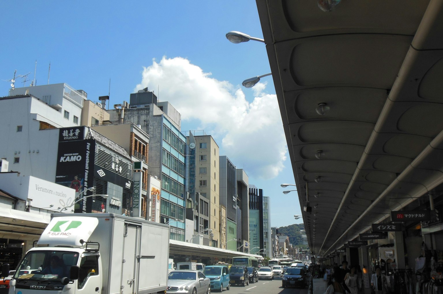 Stadtlandschaft mit Gebäuden und Lastwagen unter blauem Himmel