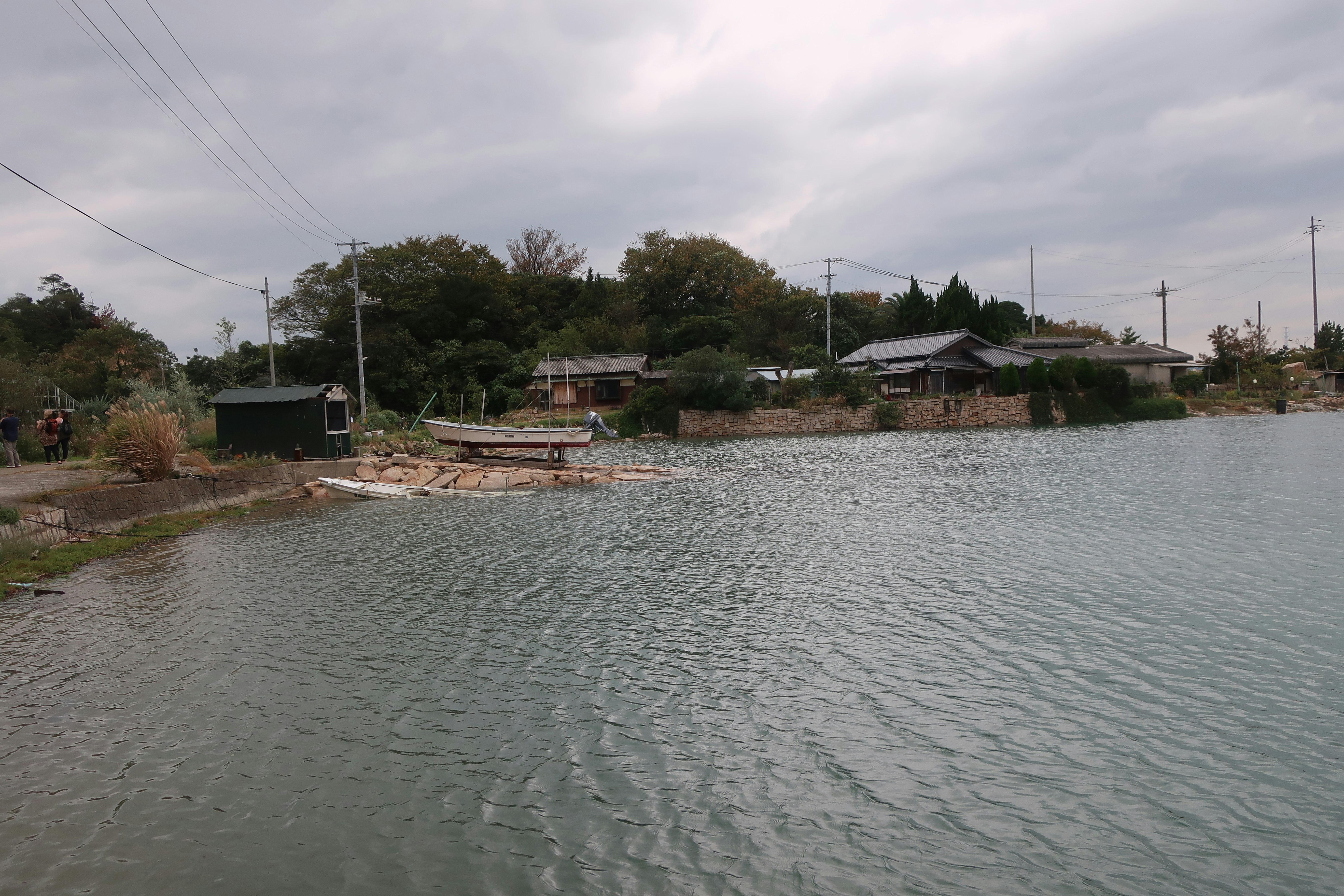 Eau calme du littoral de l’île de Naoshima avec un petit village