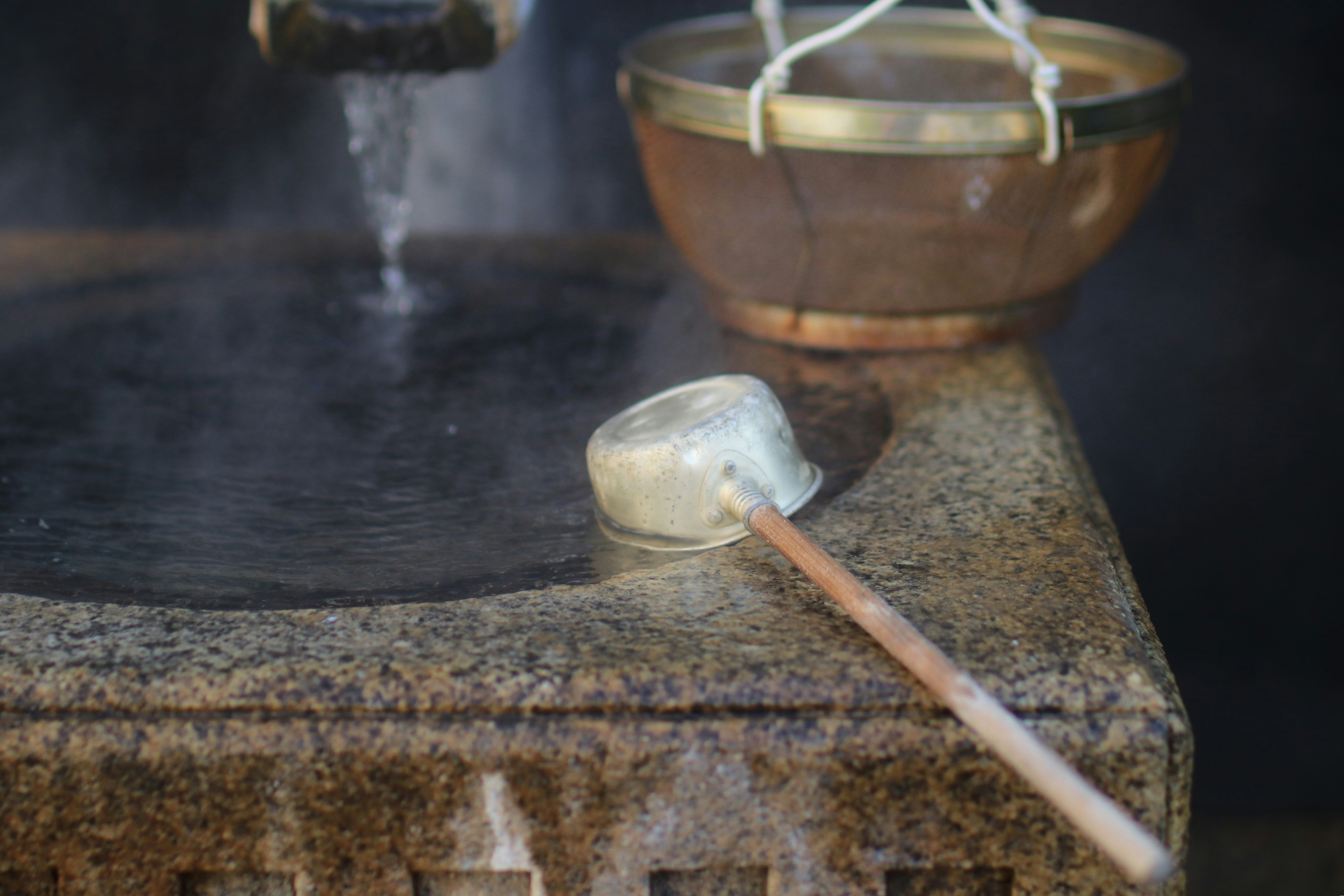 steam rising at a hand-washing basin with ladle and small cup
