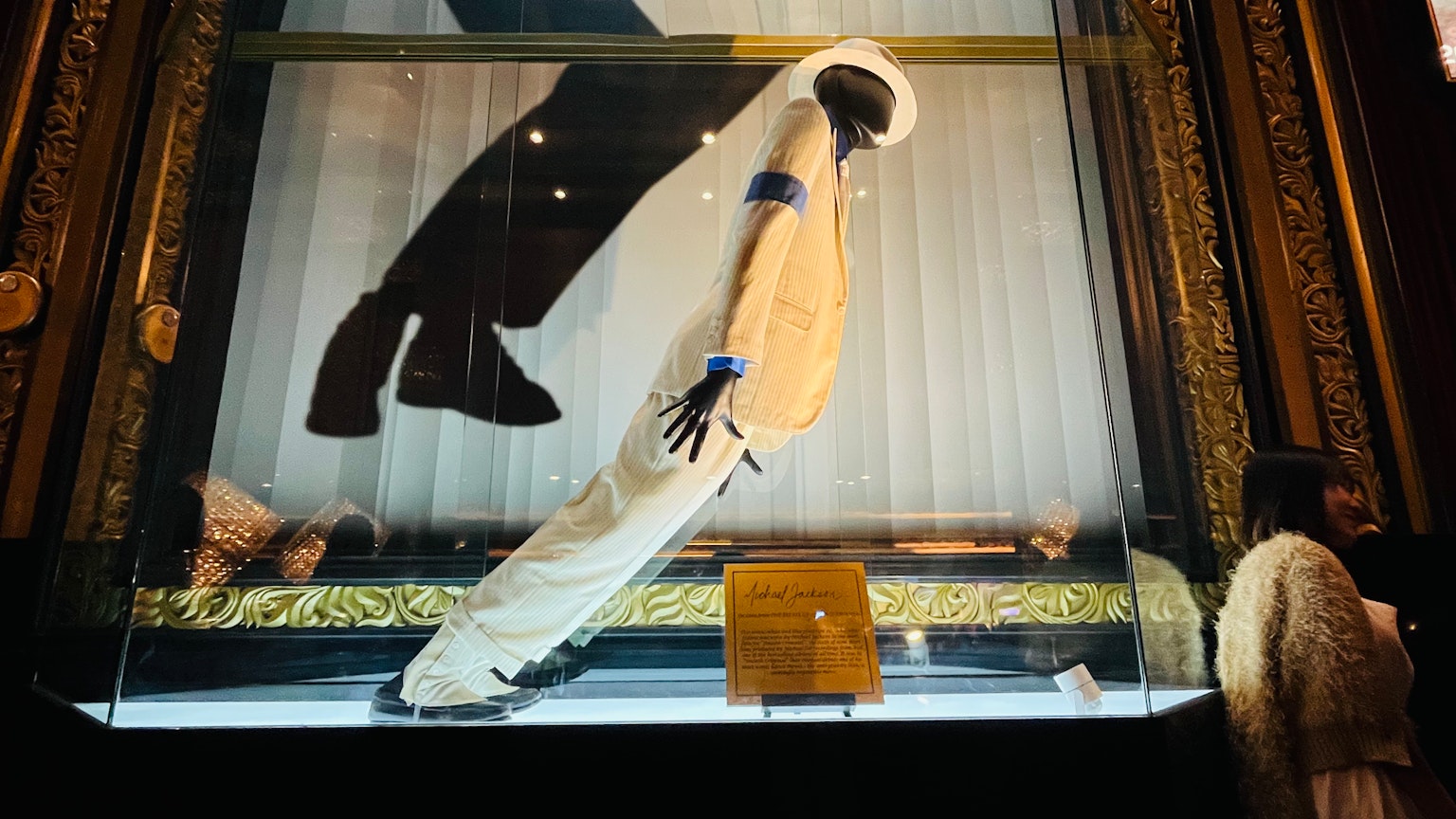 Un vêtement blanc exposé dans une vitrine avec une ombre noire d'une robe