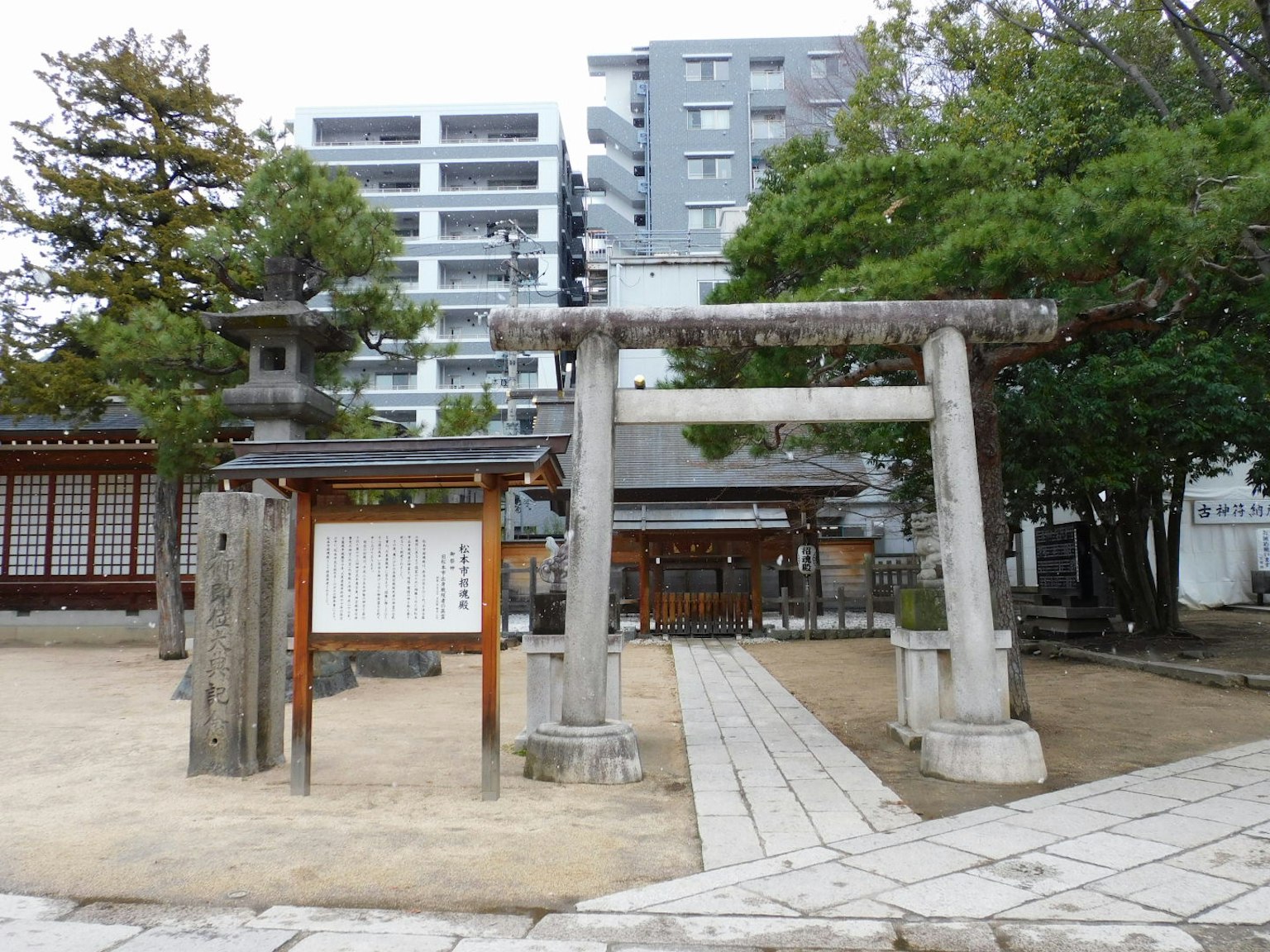 Sebuah pemandangan yang menampilkan gerbang torii tradisional di samping bangunan modern