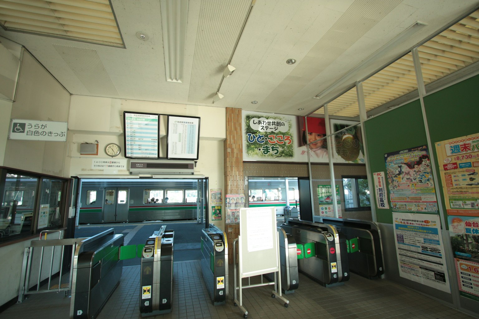 Innenansicht eines Bahnhofs mit Ticketautomaten und Werbung