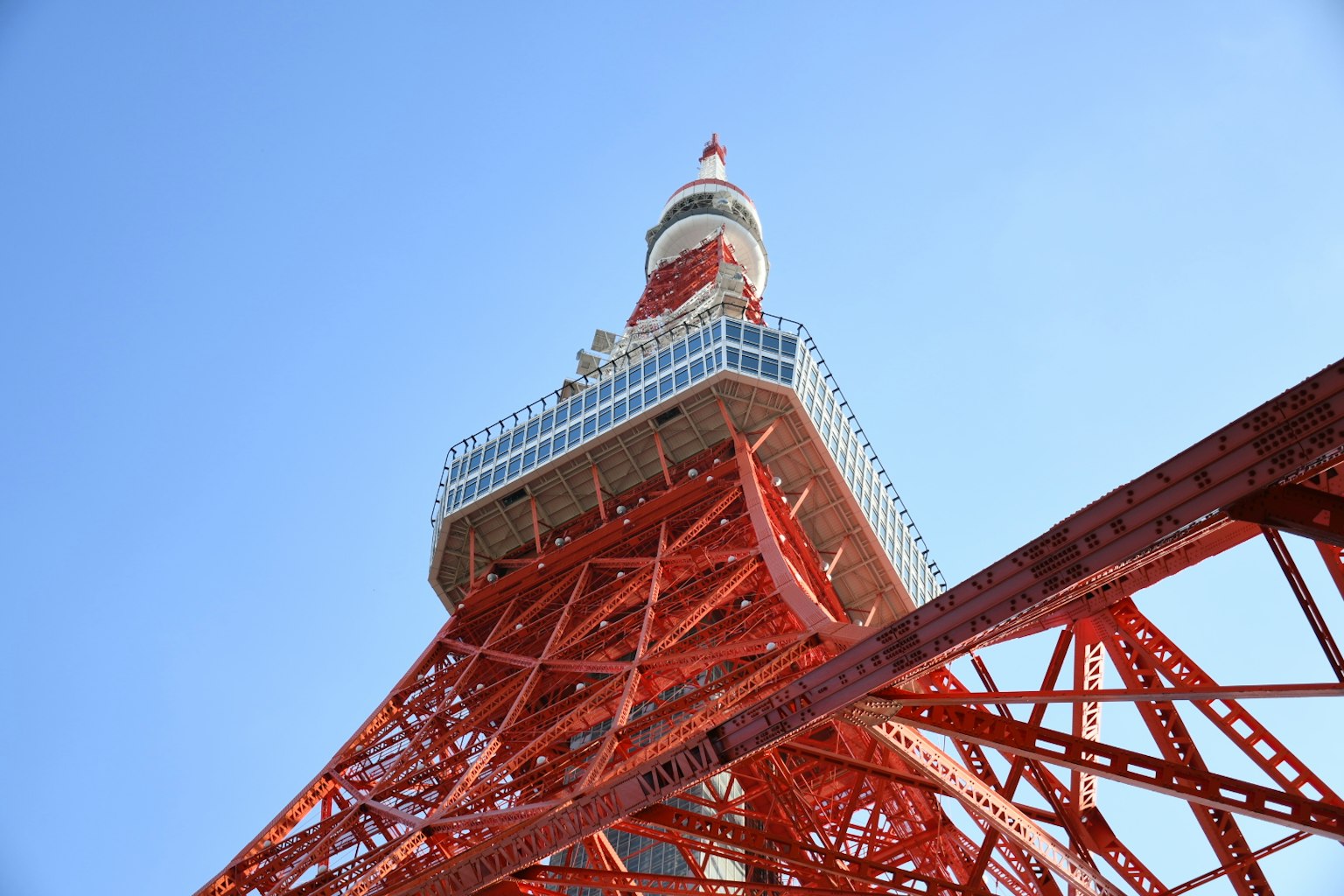 東京塔的紅色結構與清澈藍天背景下的低角度視圖