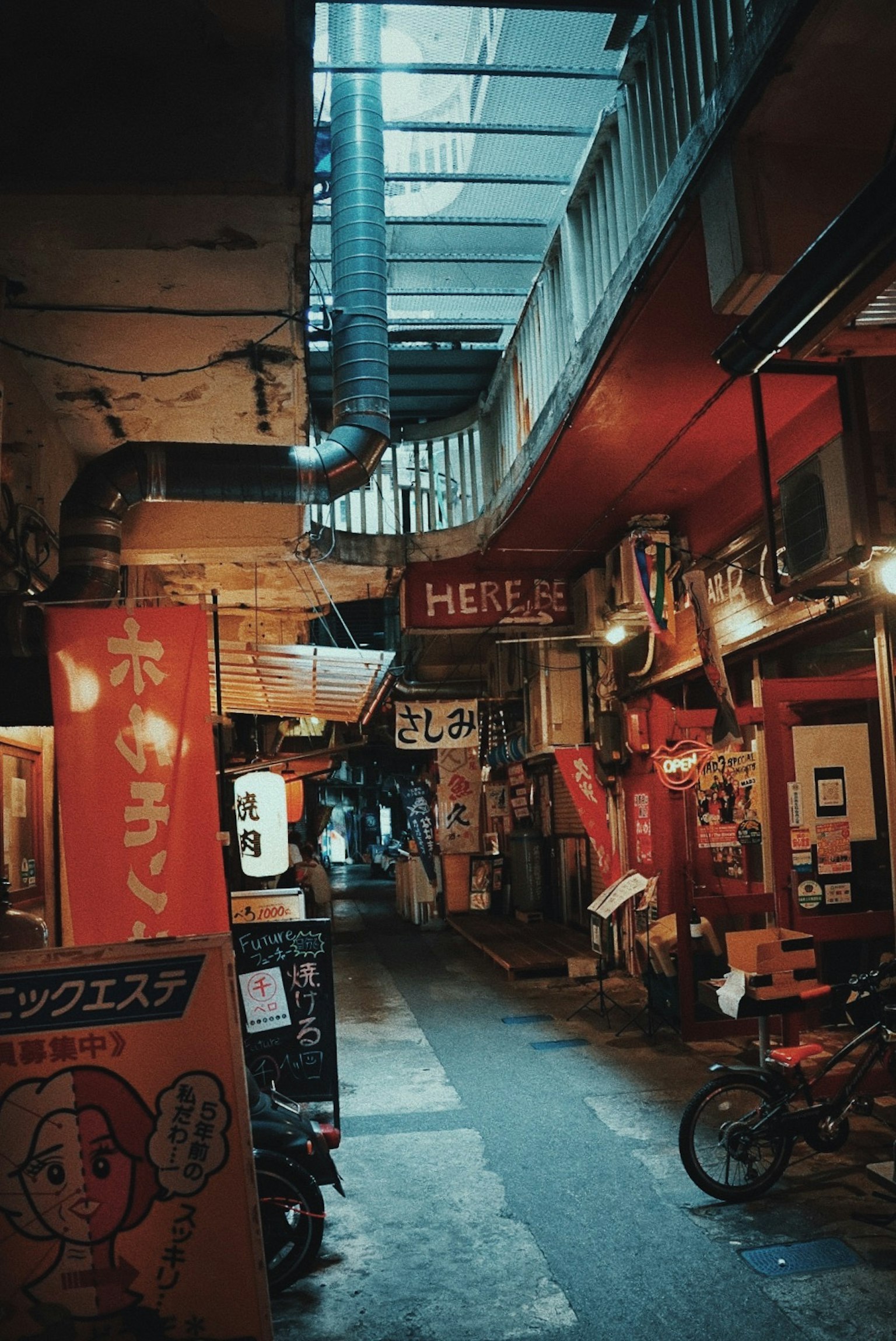 Callejón estrecho con letreros de restaurantes y una bicicleta en una escena nocturna