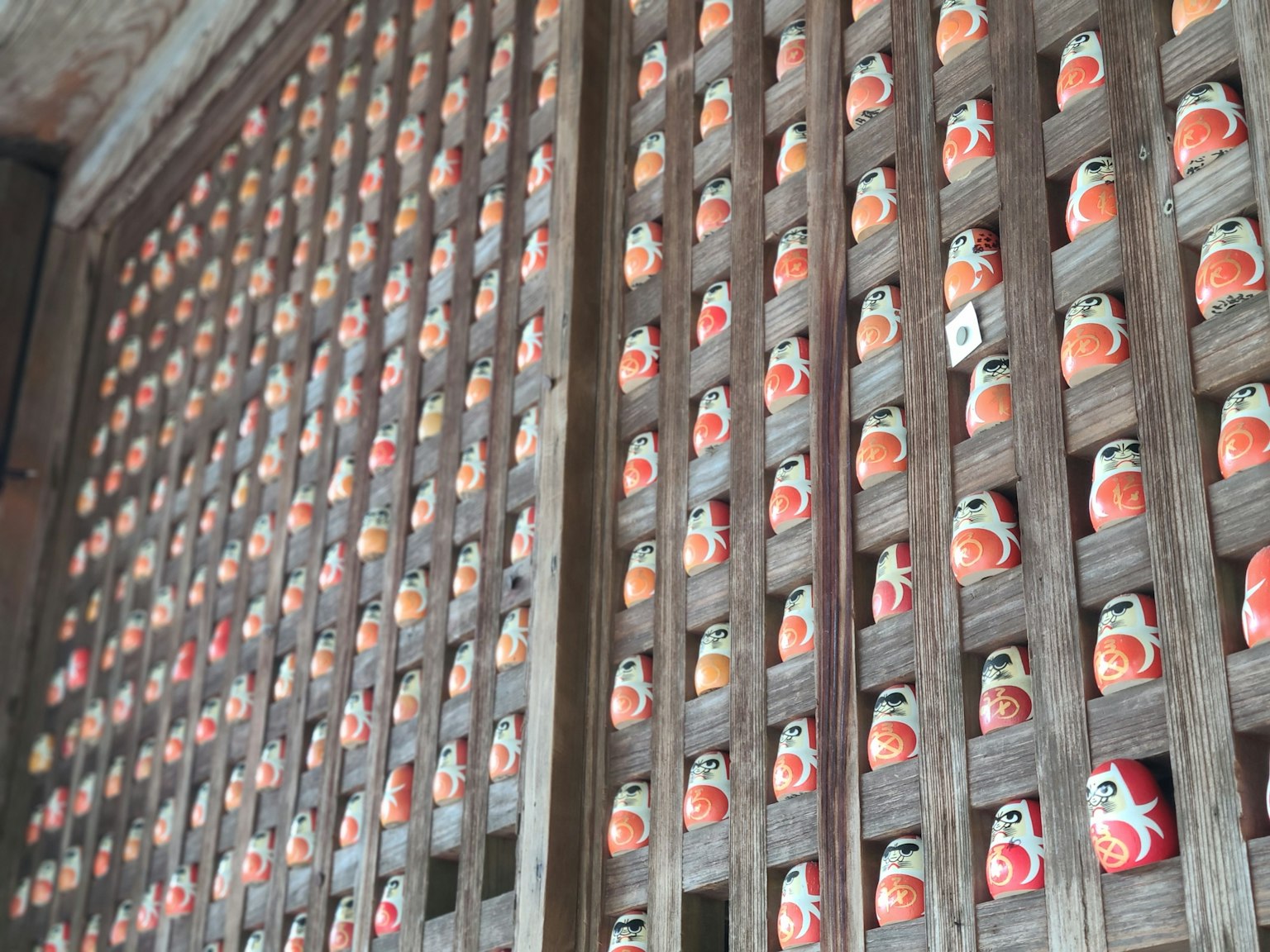 Un mur en bois rempli de nombreuses petites figurines en céramique