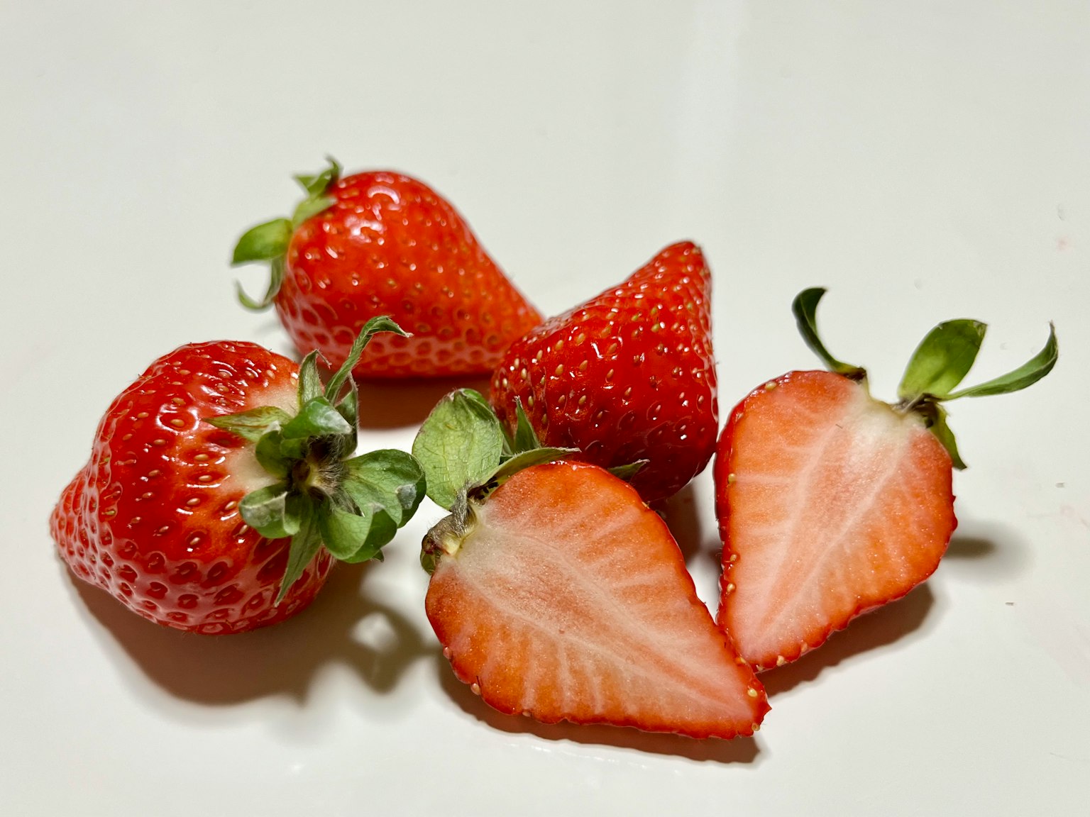 Fresh red strawberries arranged on a white plate