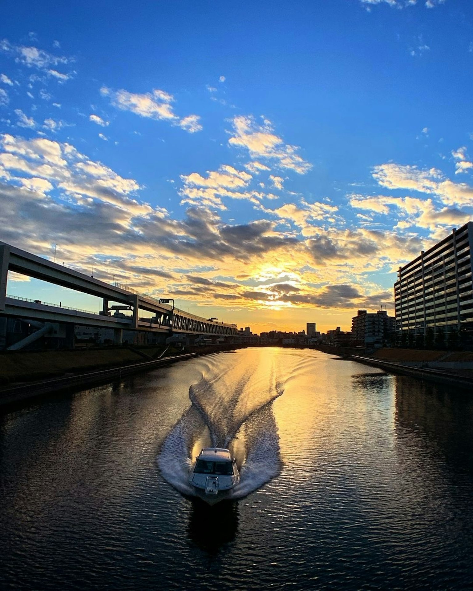 Vista panoramica di una barca che scivola sull'acqua sotto un tramonto colorato