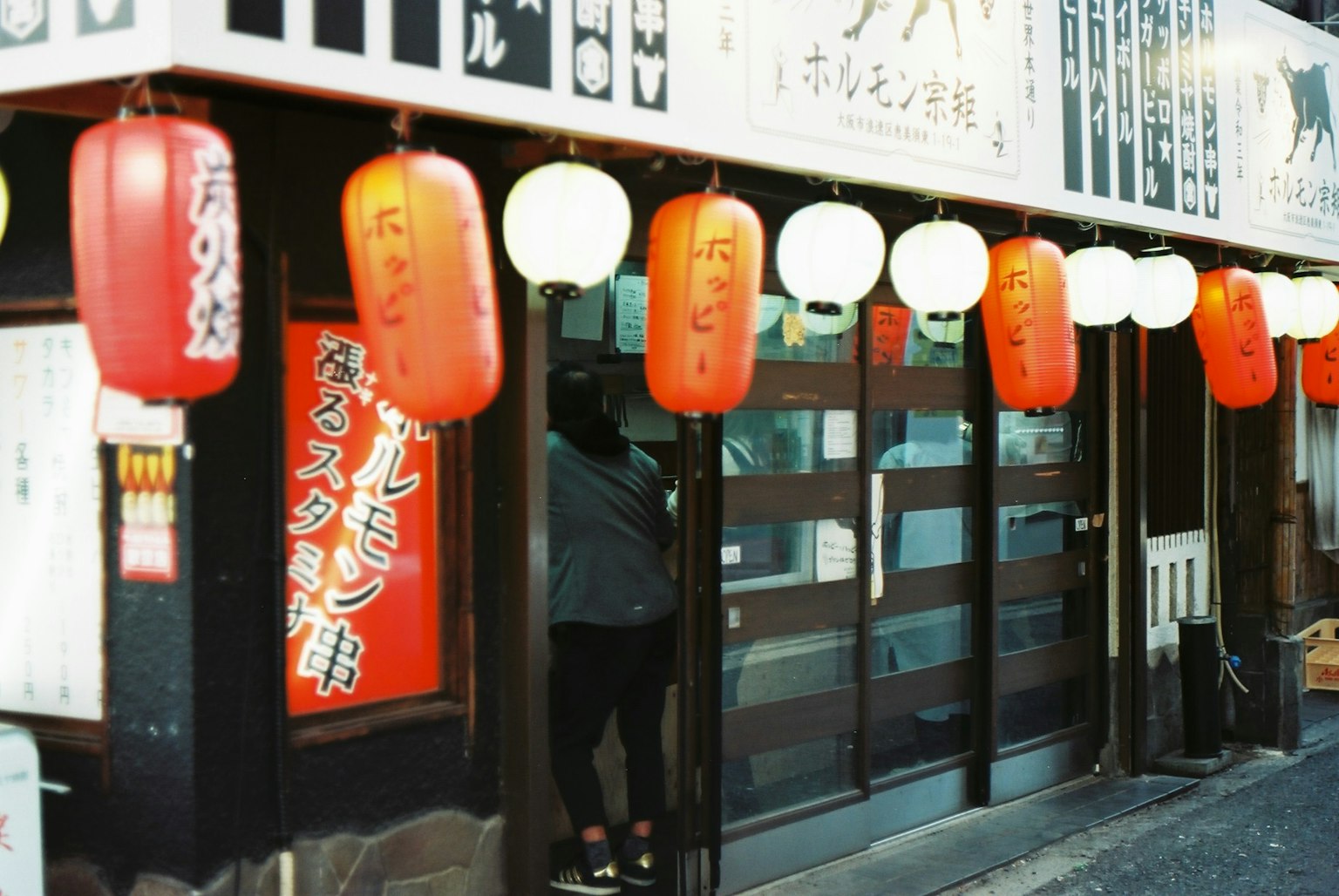 Extérieur d'un restaurant japonais orné de lanternes rouges et de lumières blanches