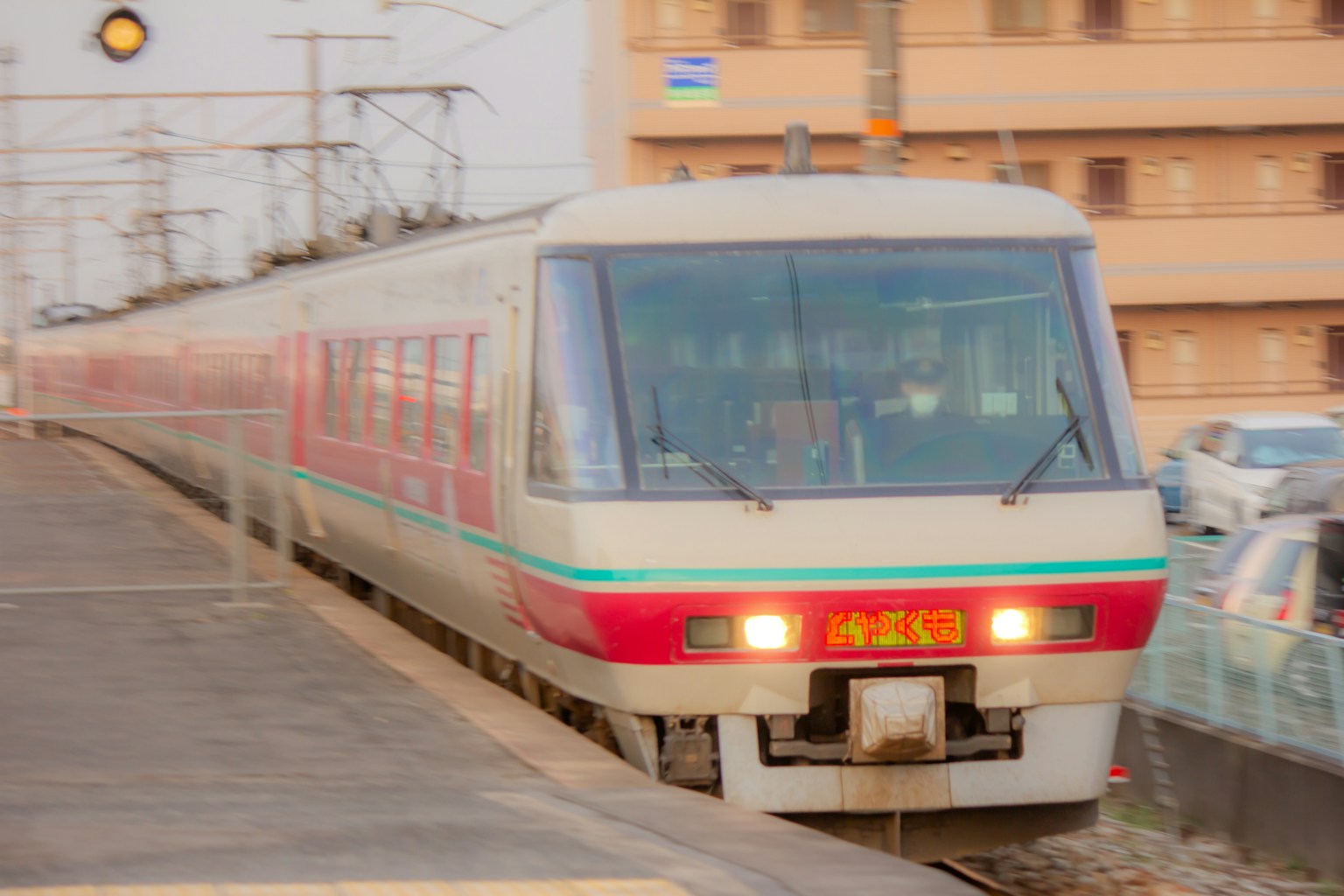 Kereta merah dan putih mendekati stasiun