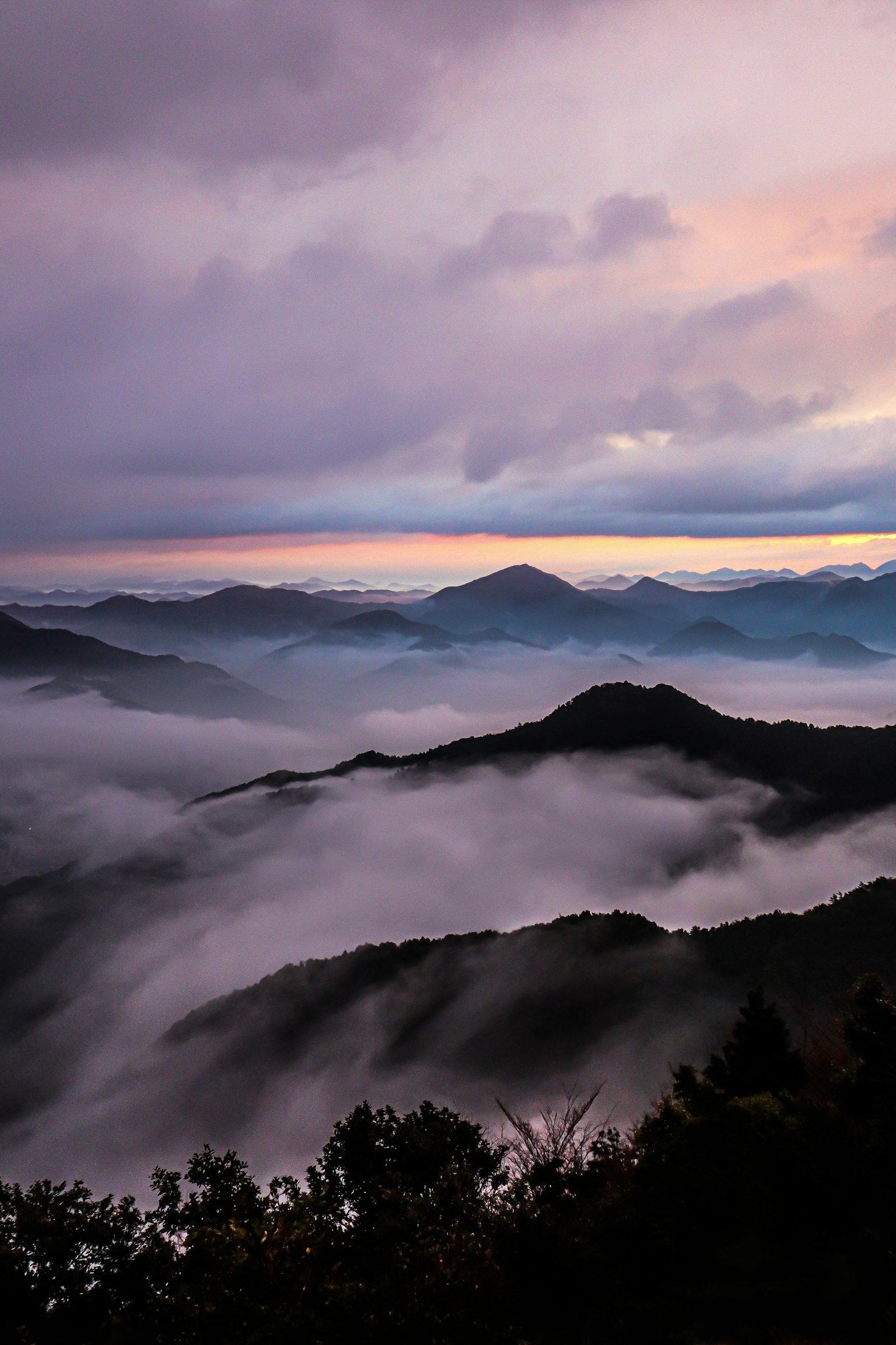 黄昏时分的山脉景观，伴有雾和云