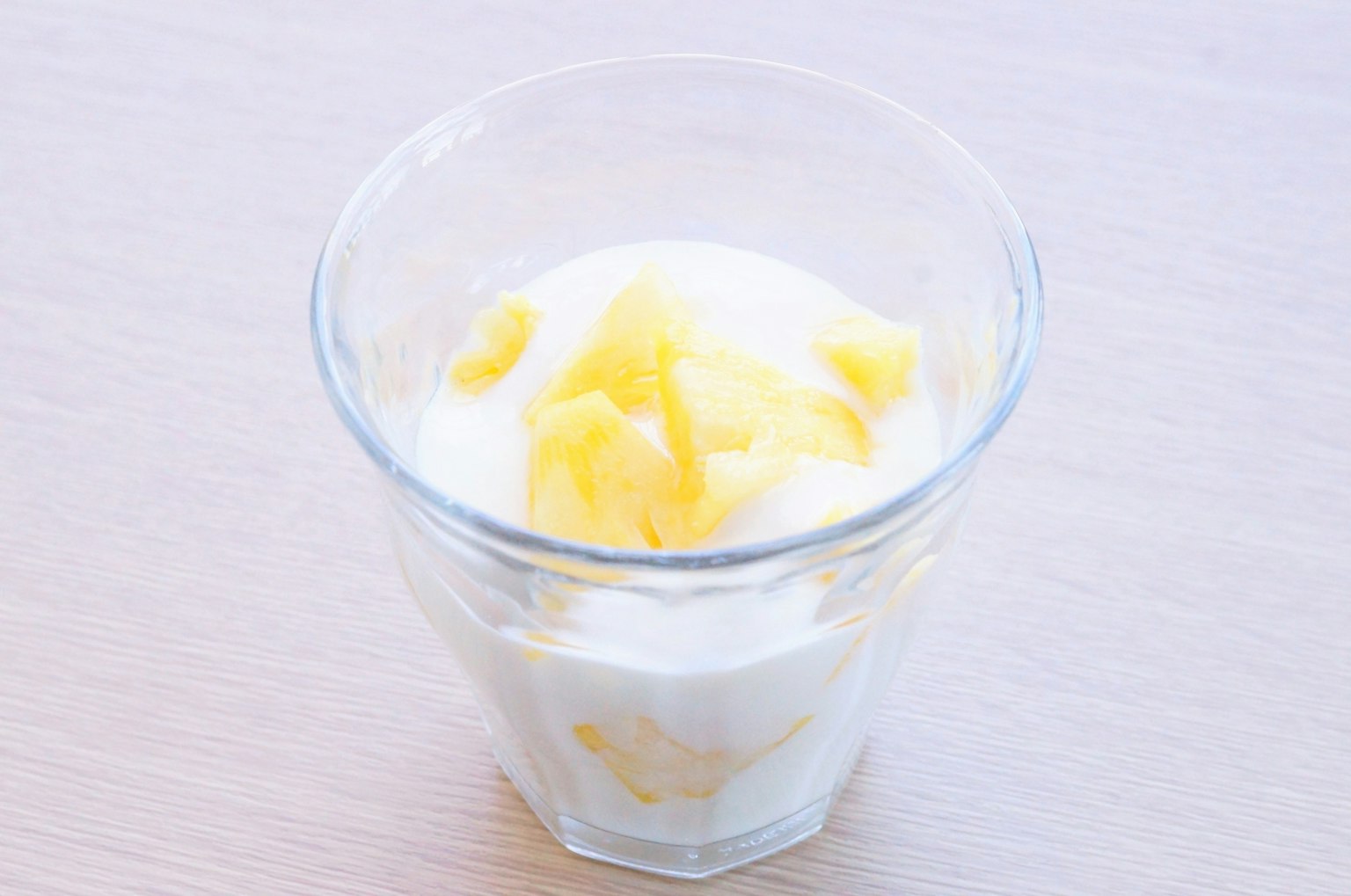 Yogurt topped with mango pieces in a clear glass