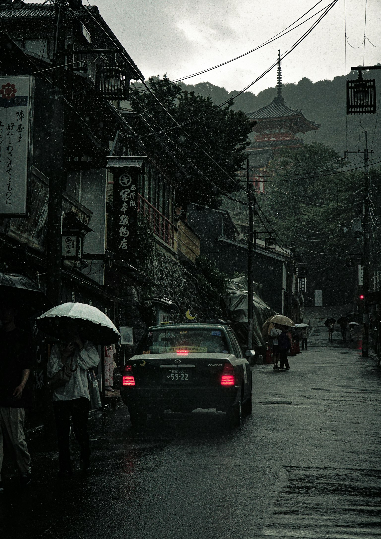 ฉากถนนในฝนพร้อมแท็กซี่และคนเดินถนน