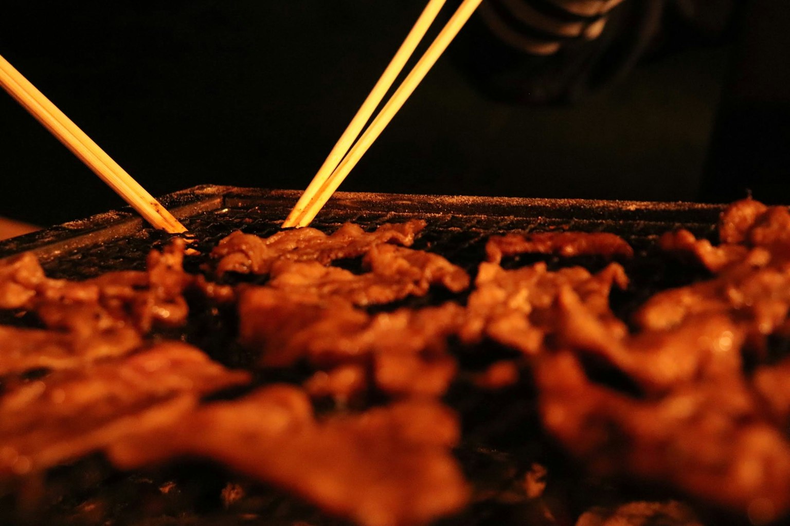 Carne asada con palillos en un ambiente de barbacoa