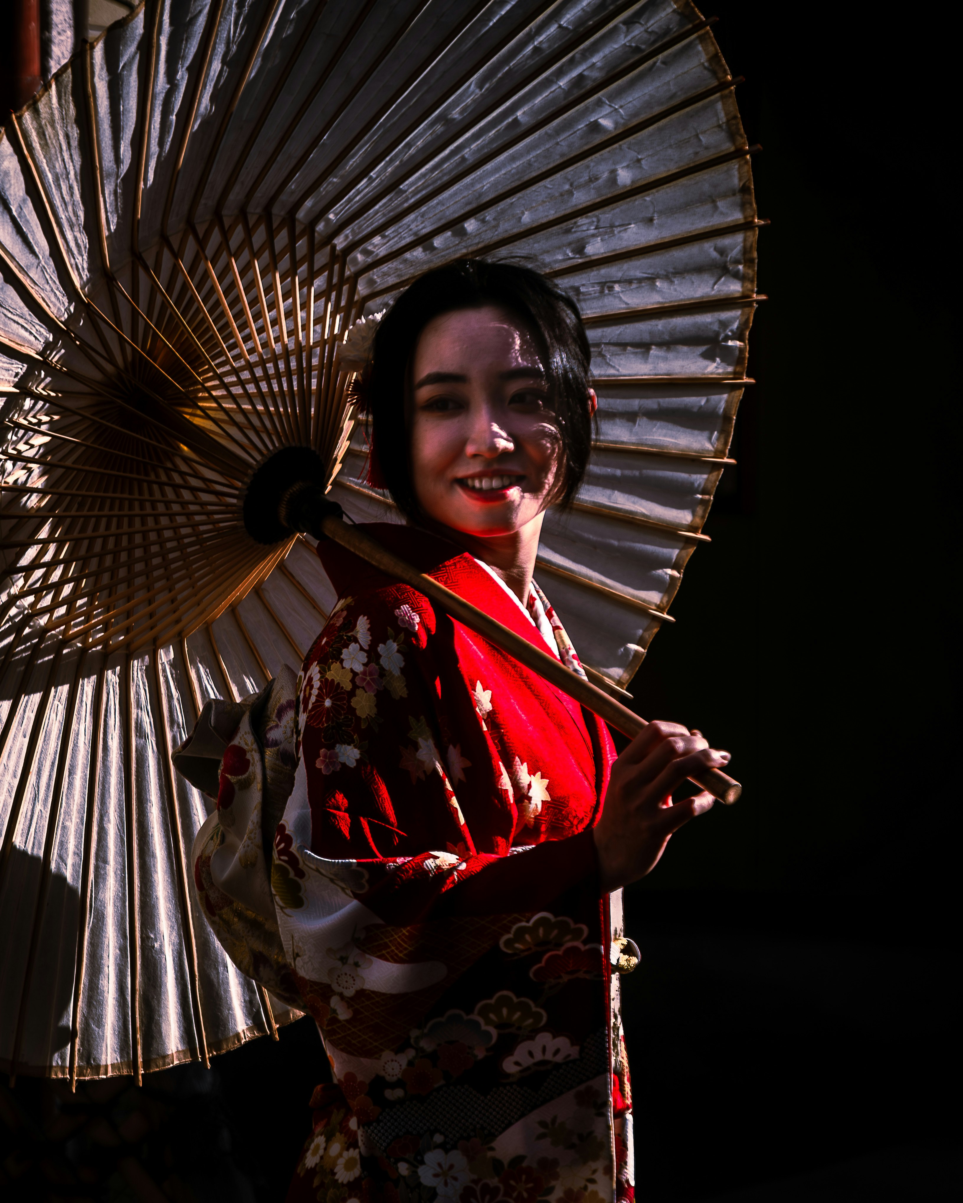 Frau im Kimono mit einem traditionellen japanischen Regenschirm