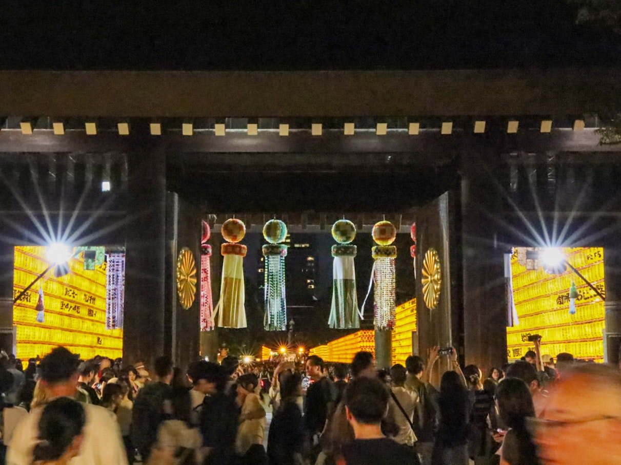 Strada notturna al festival Mitama del Santuario Yasukuni con lanterne e bancarelle