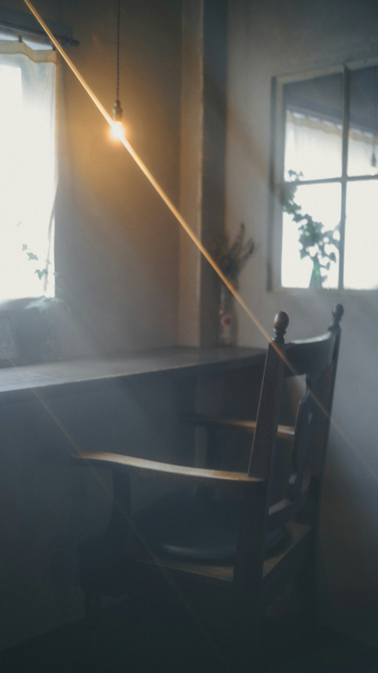 木製の椅子とテーブルがある静かな部屋の一角 窓からの柔らかい光が差し込む