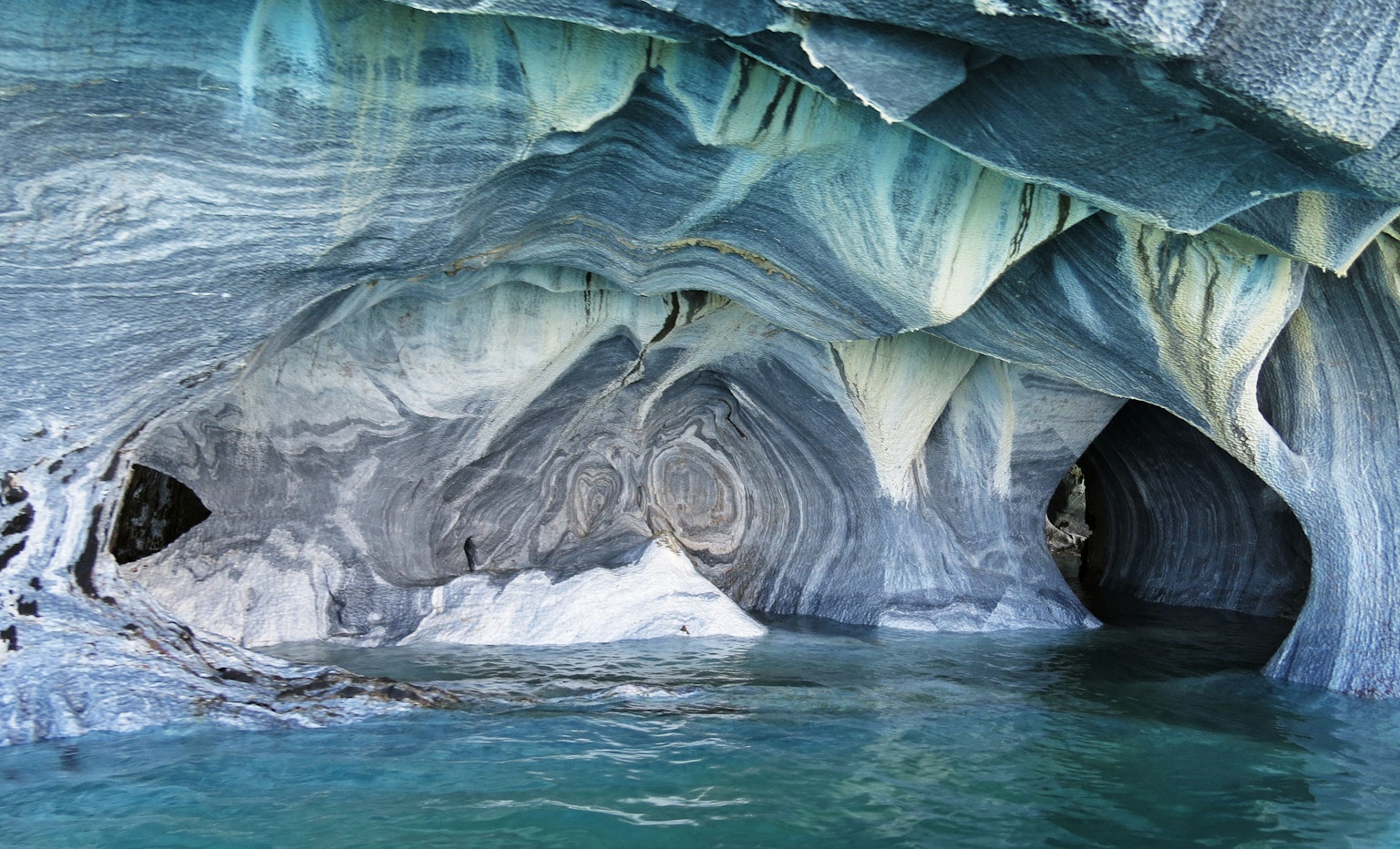 Intérieur d'une magnifique grotte de marbre avec de l'eau turquoise