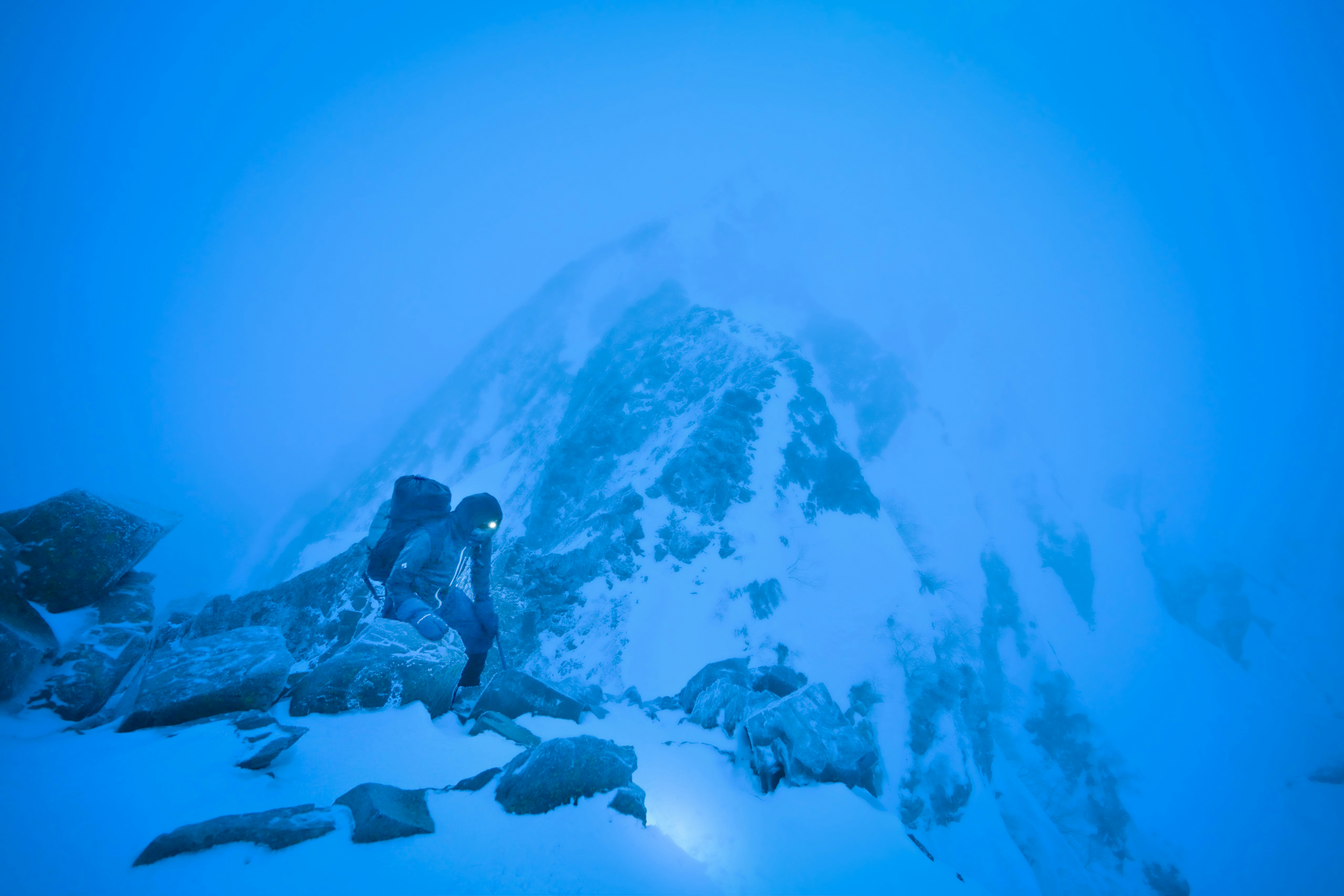 青い霧の中の雪山と岩場