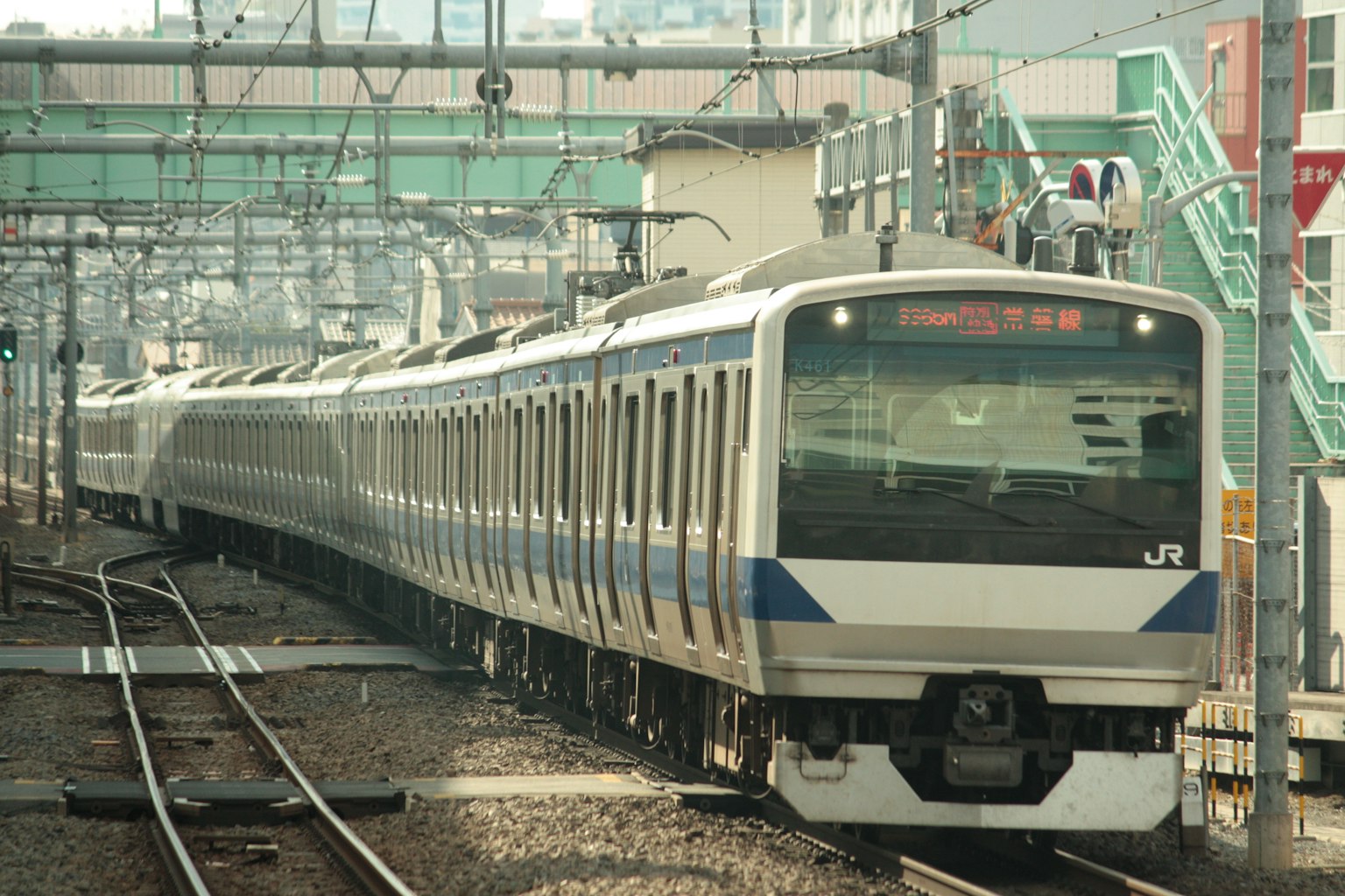 一列白色車身的日本火車在軌道上行駛