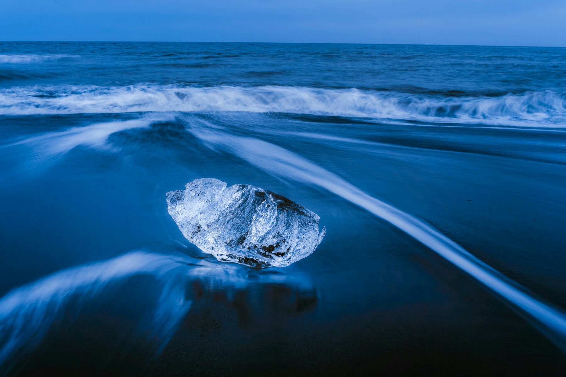 ocean shoreline with a rock and crashing waves