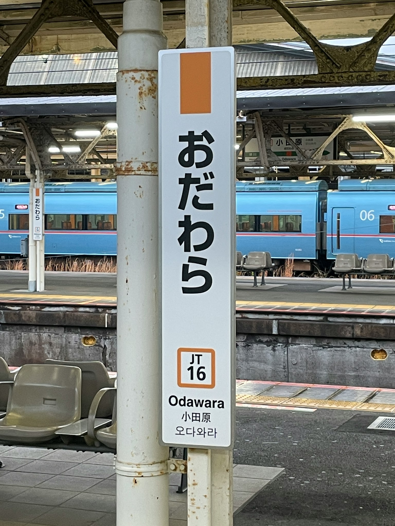 小田原車站標誌和可見的藍色列車在月台上