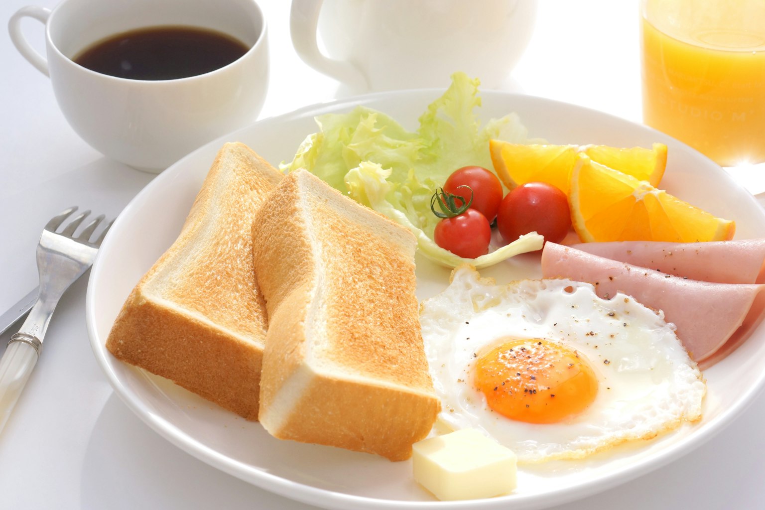 早餐盘包含吐司、煎蛋、生菜、小番茄、水果和火腿