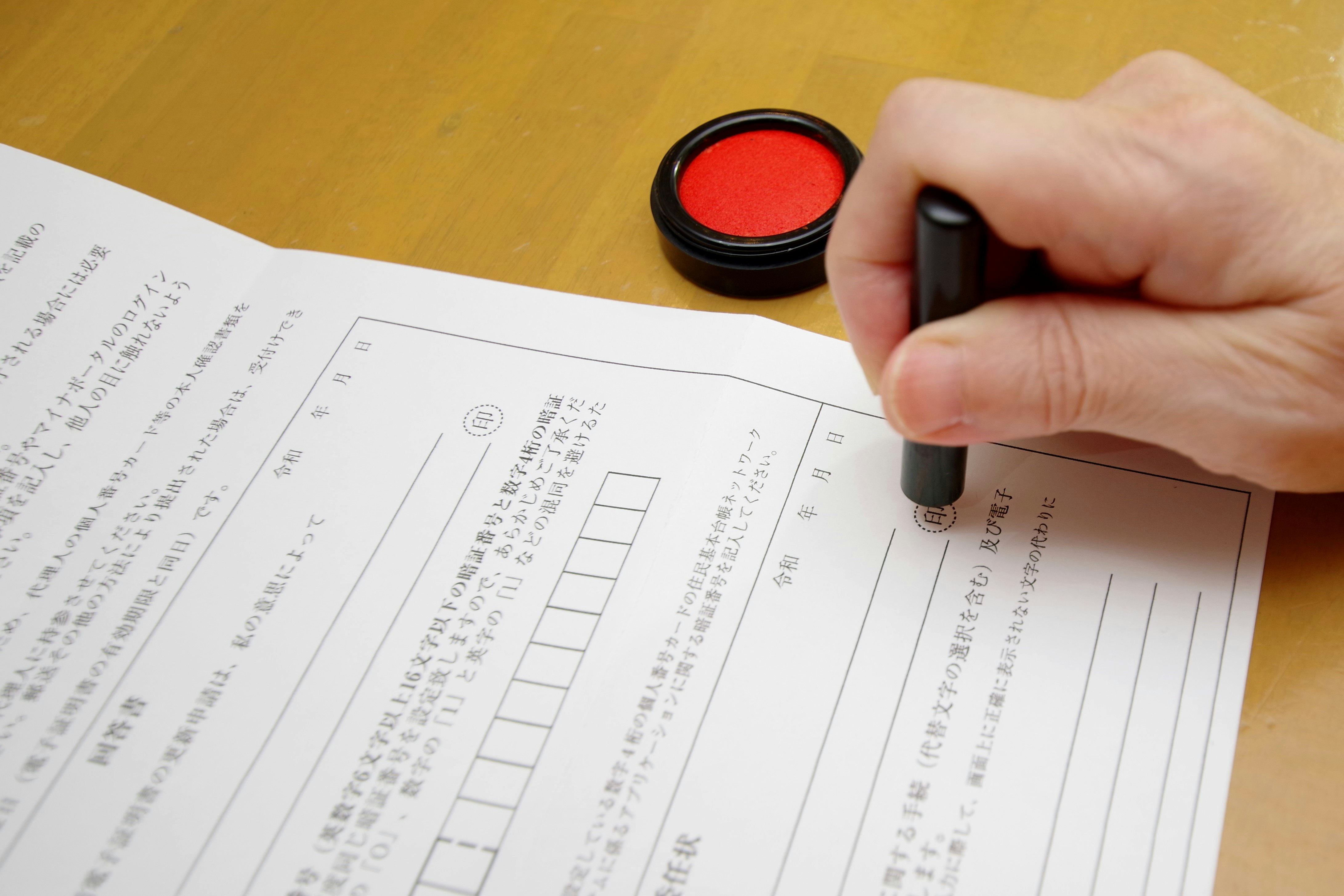 hand filling out a form with a pen