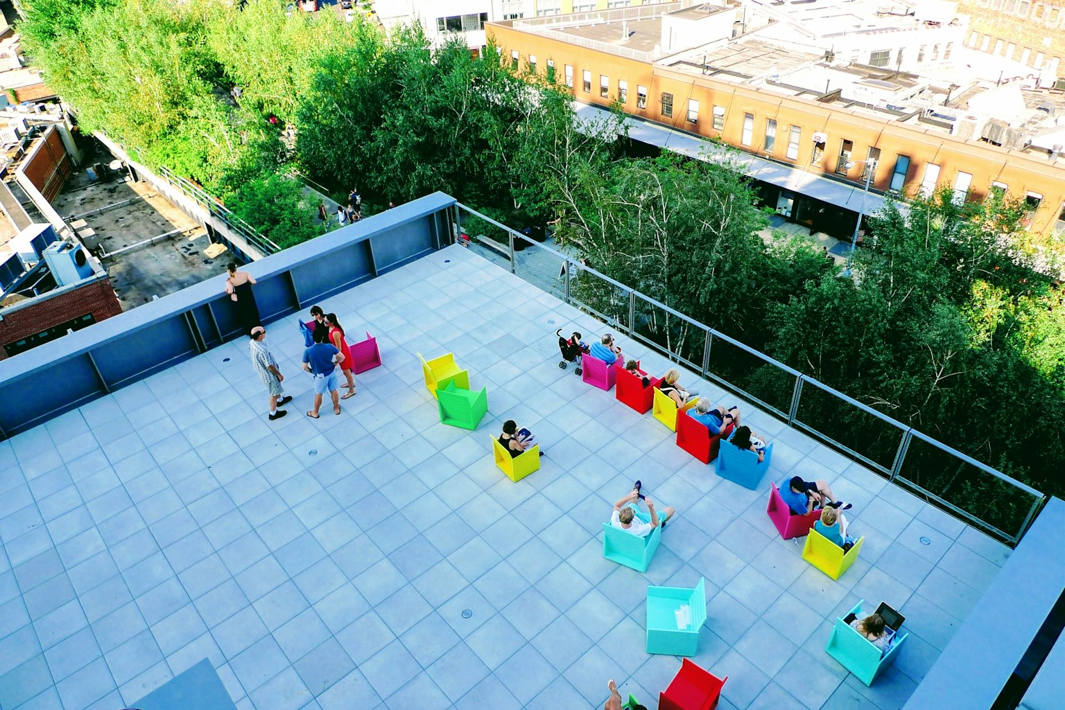 Scène sur le toit avec des personnes assises sur des chaises colorées