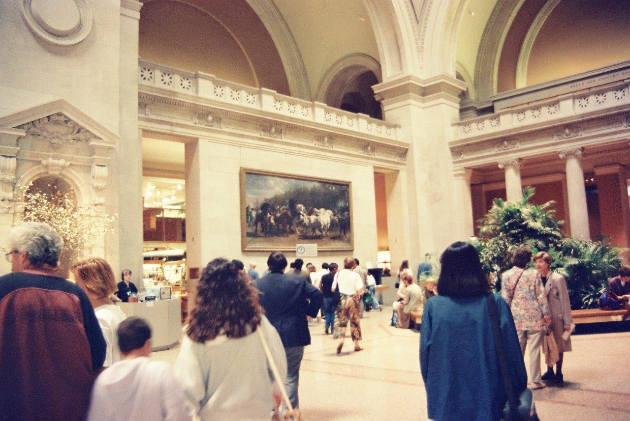 大きなアーチと柱のある美術館ホールで人々が歩く