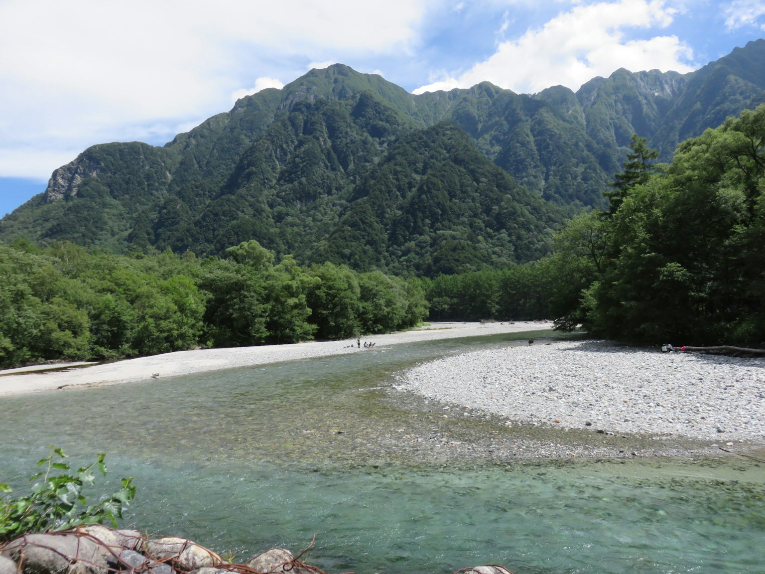 Malersicher Blick auf einen Fluss, umgeben von Bergen und üppigem Grün