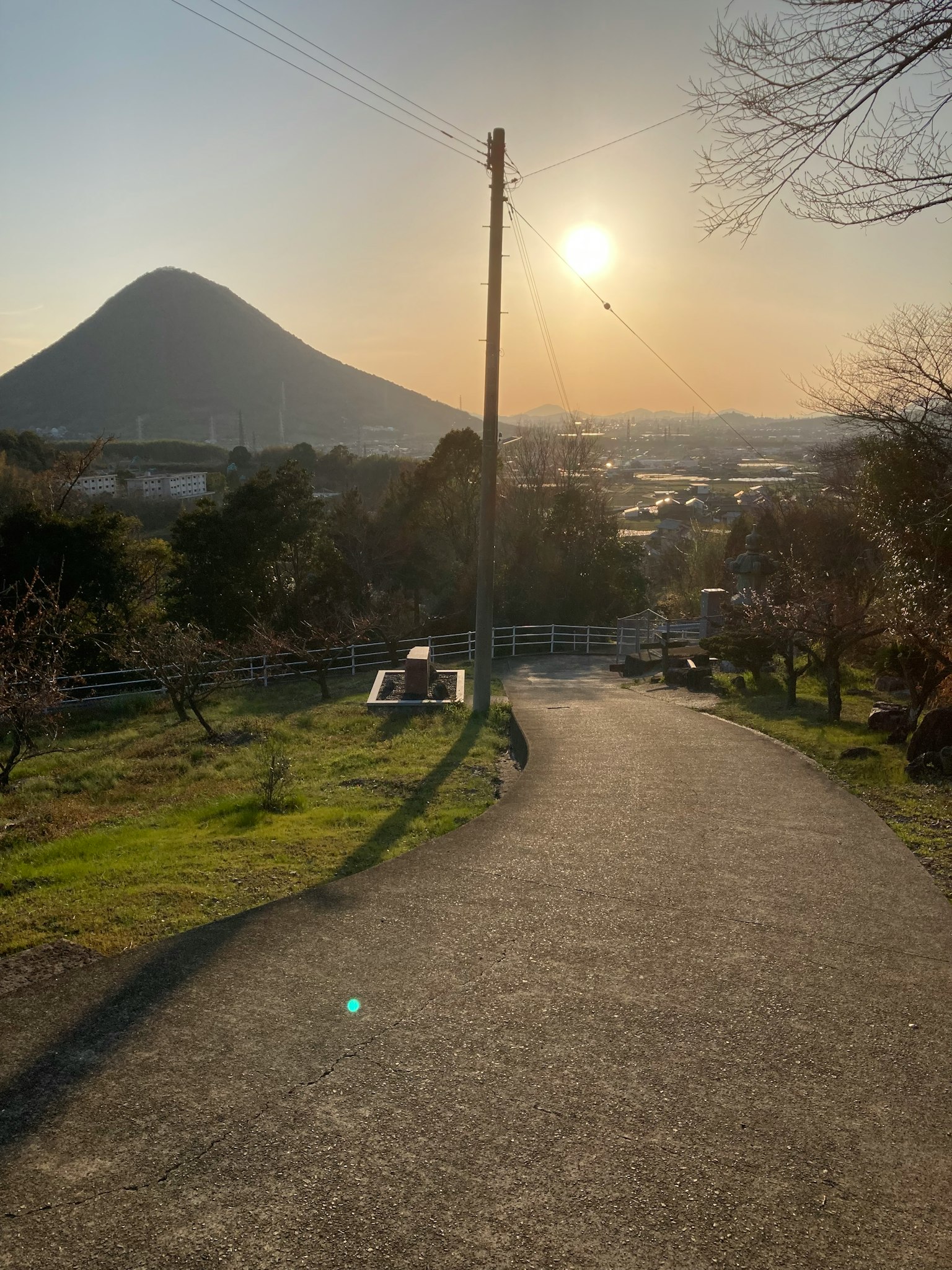 Malereischer Weg, der zu einem Berg und einem Sonnenuntergang führt