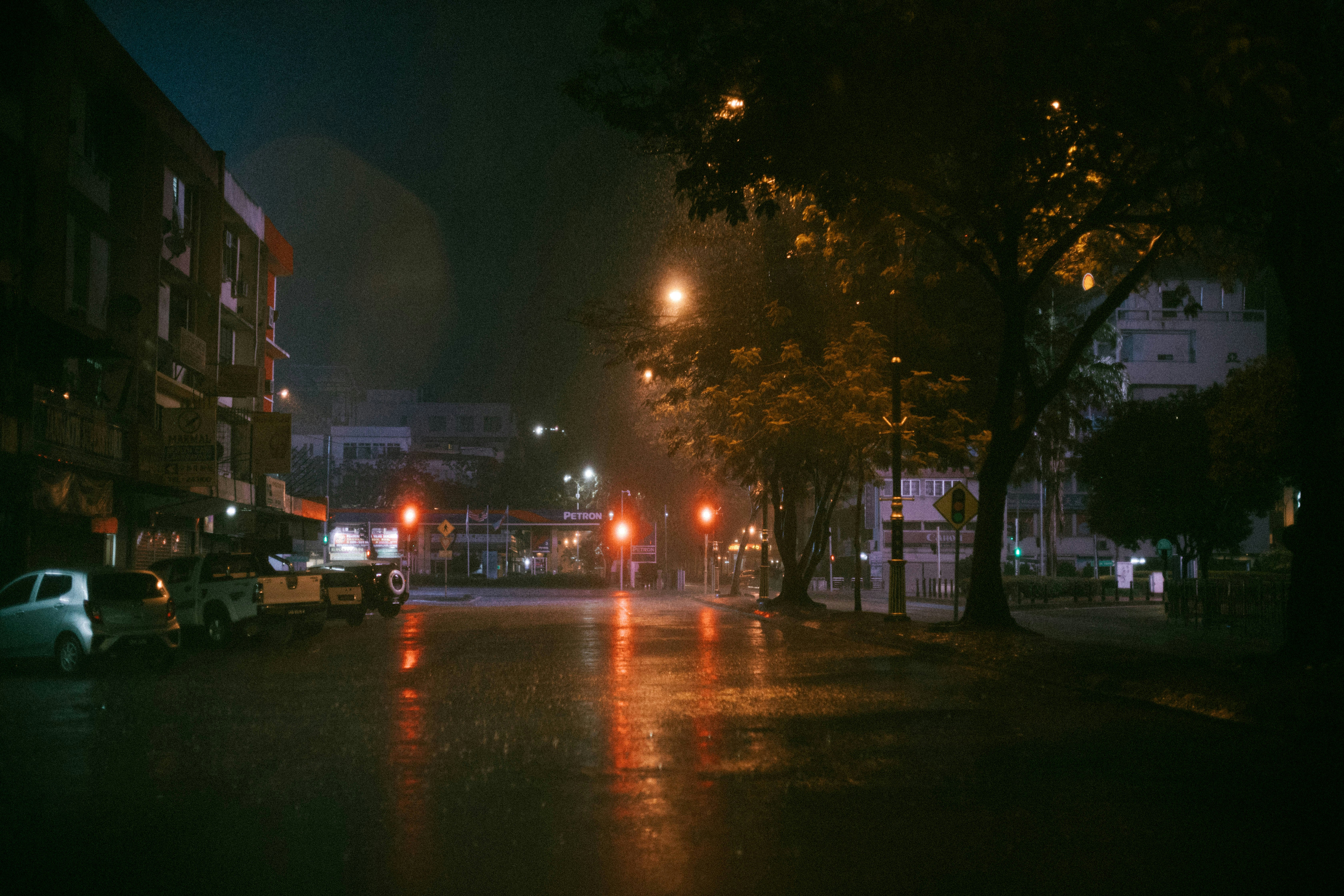 雨の夜に街灯が反射する空の通り