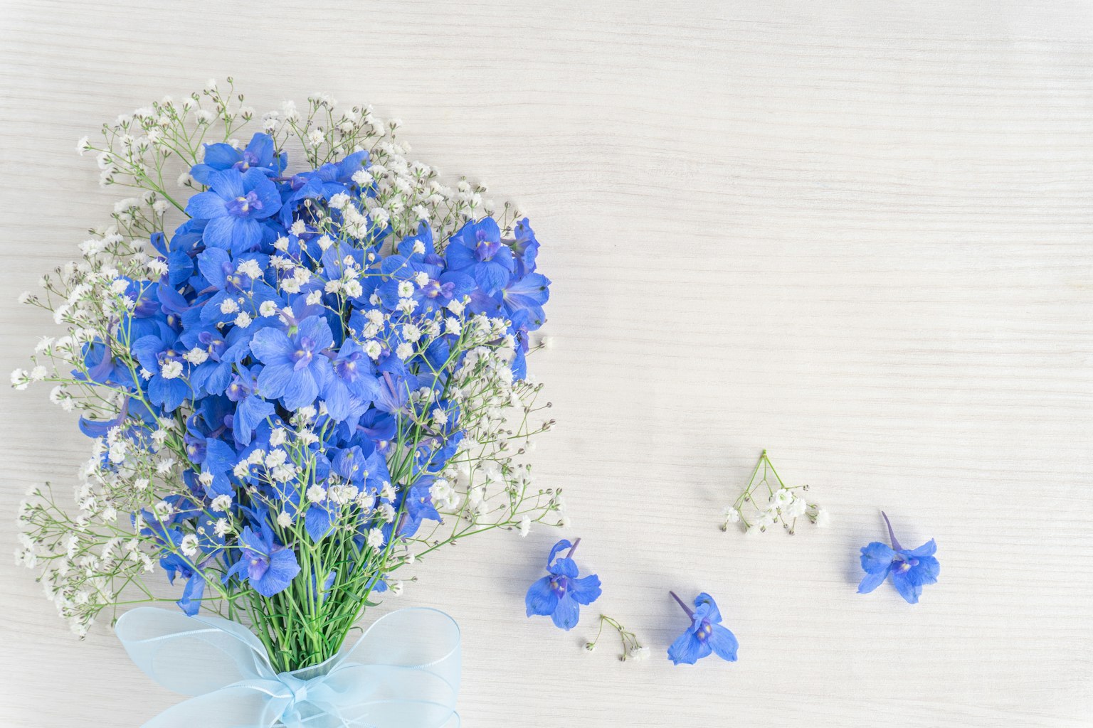 Susunan indah dengan buket bunga biru dan bunga kecil putih