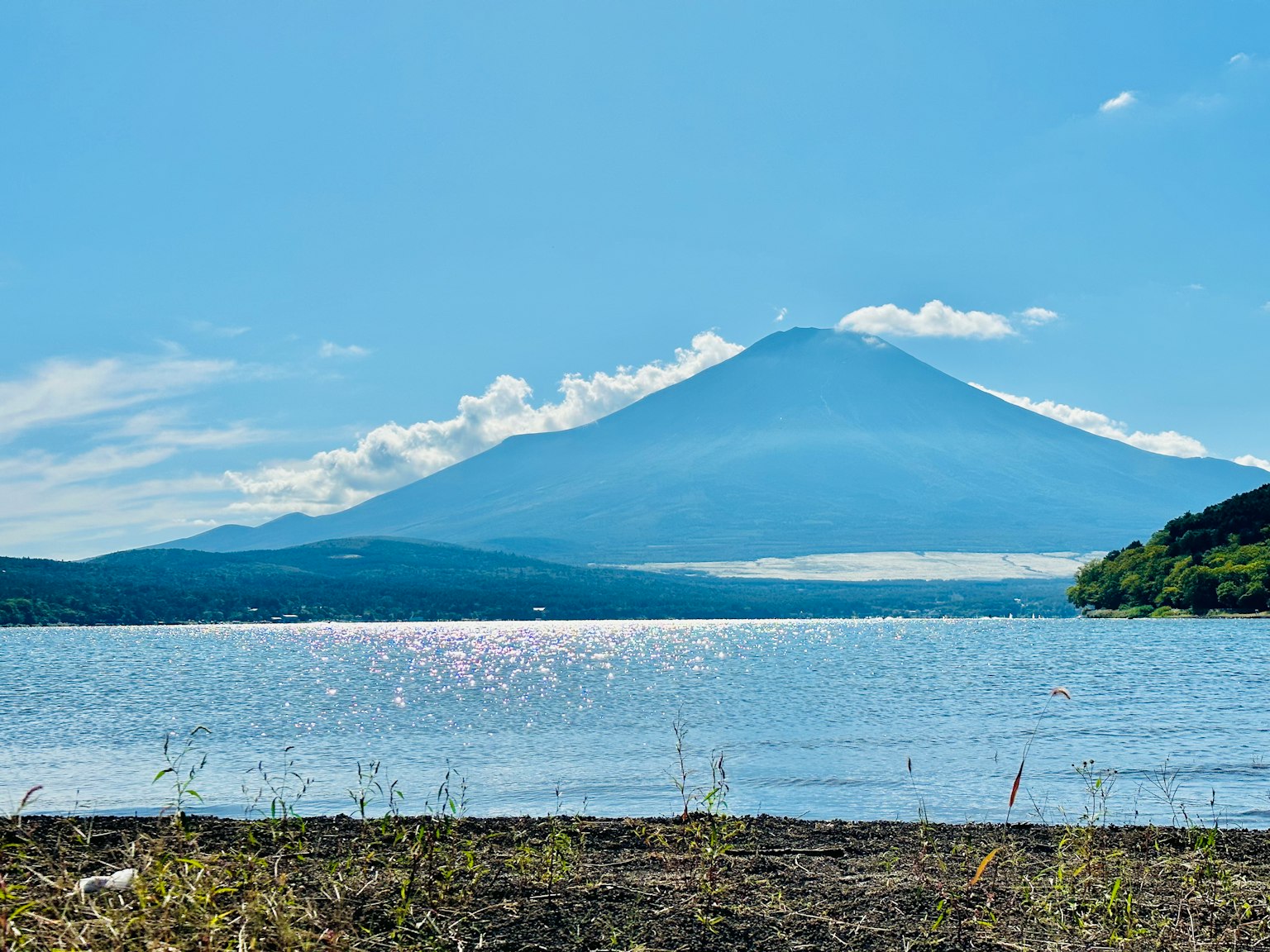 Vista panoramica del Monte Fuji attraverso il lago con cielo azzurro e nuvole sparse