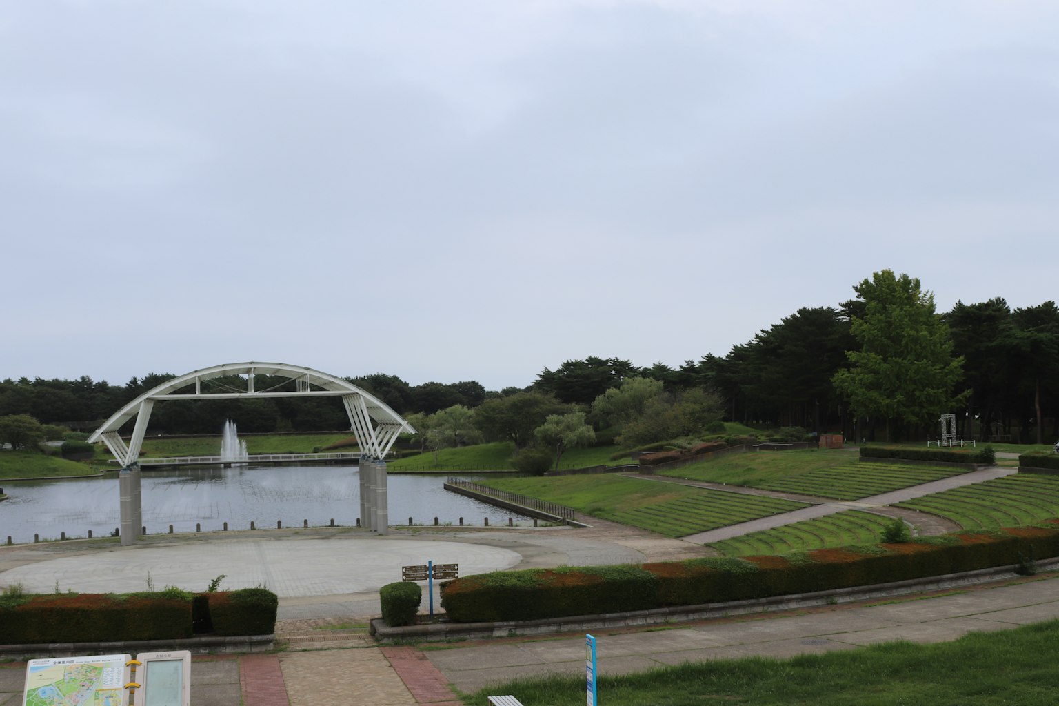 ทิวทัศน์ของสวนที่มีสะพานสีขาวและบ่อน้ำสงบ